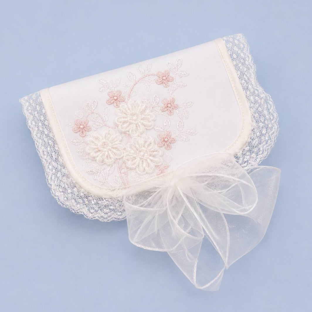First Curl Keepsake Box with delicate pink floral embroidery, white lace trim, and a sheer white organza ribbon bow, displayed on a light blue background.
