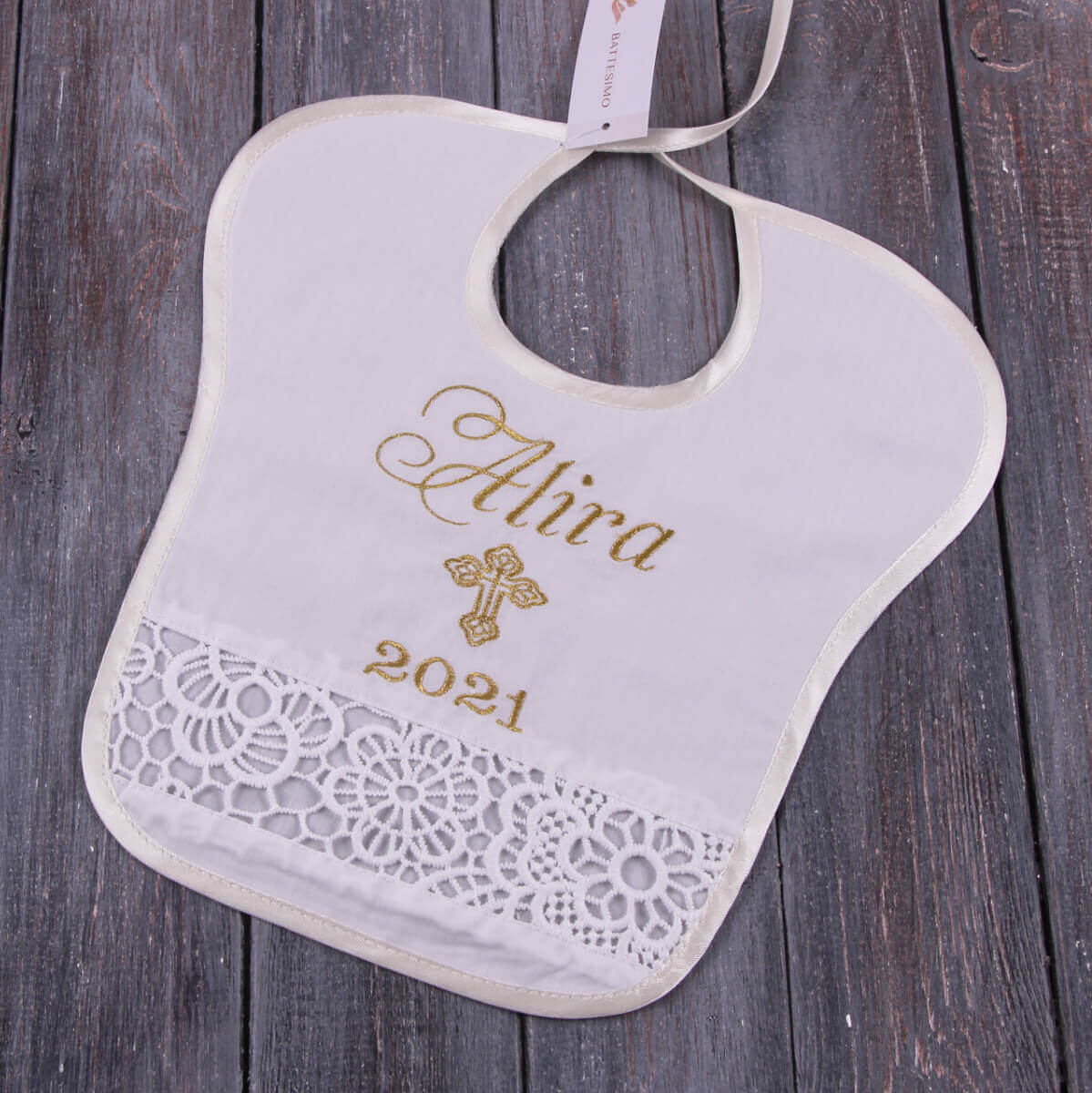 Baptism Bib with embroidered name and year on a wooden surface