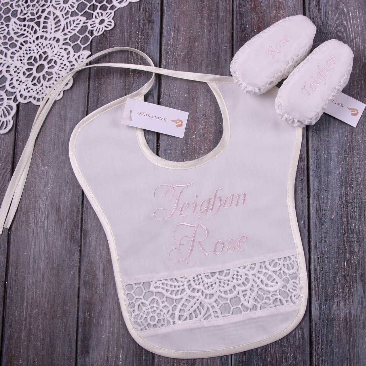 Baptism Bib with lace details and embroidered name on a wooden surface