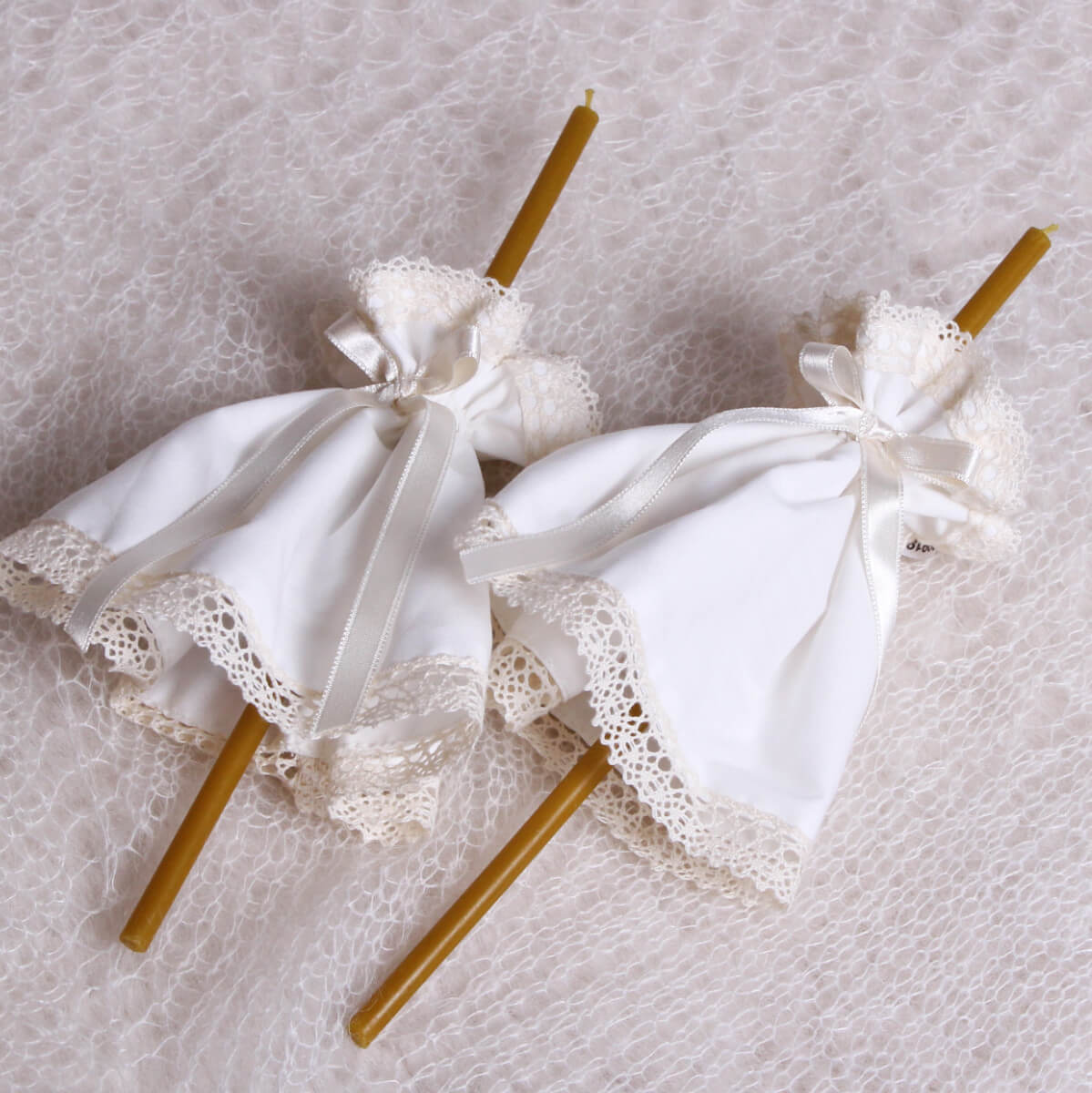 Two decorative candles with Fabric Candle Wraps on a textured surface