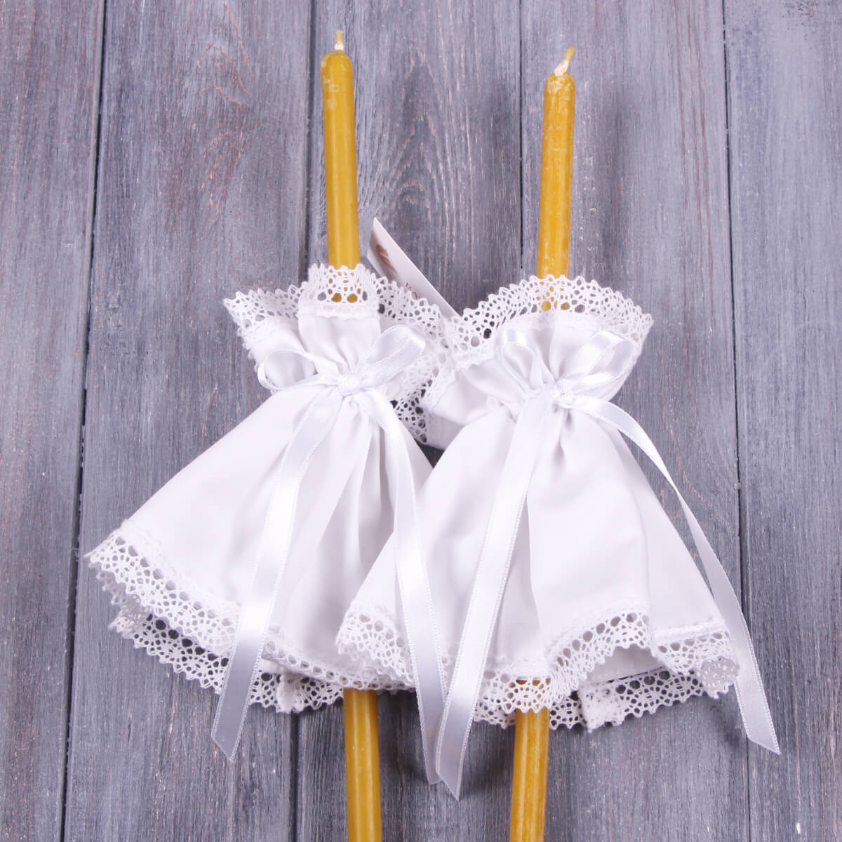Fabric Candle Wraps with white lace and ribbon decorations on a wooden surface.