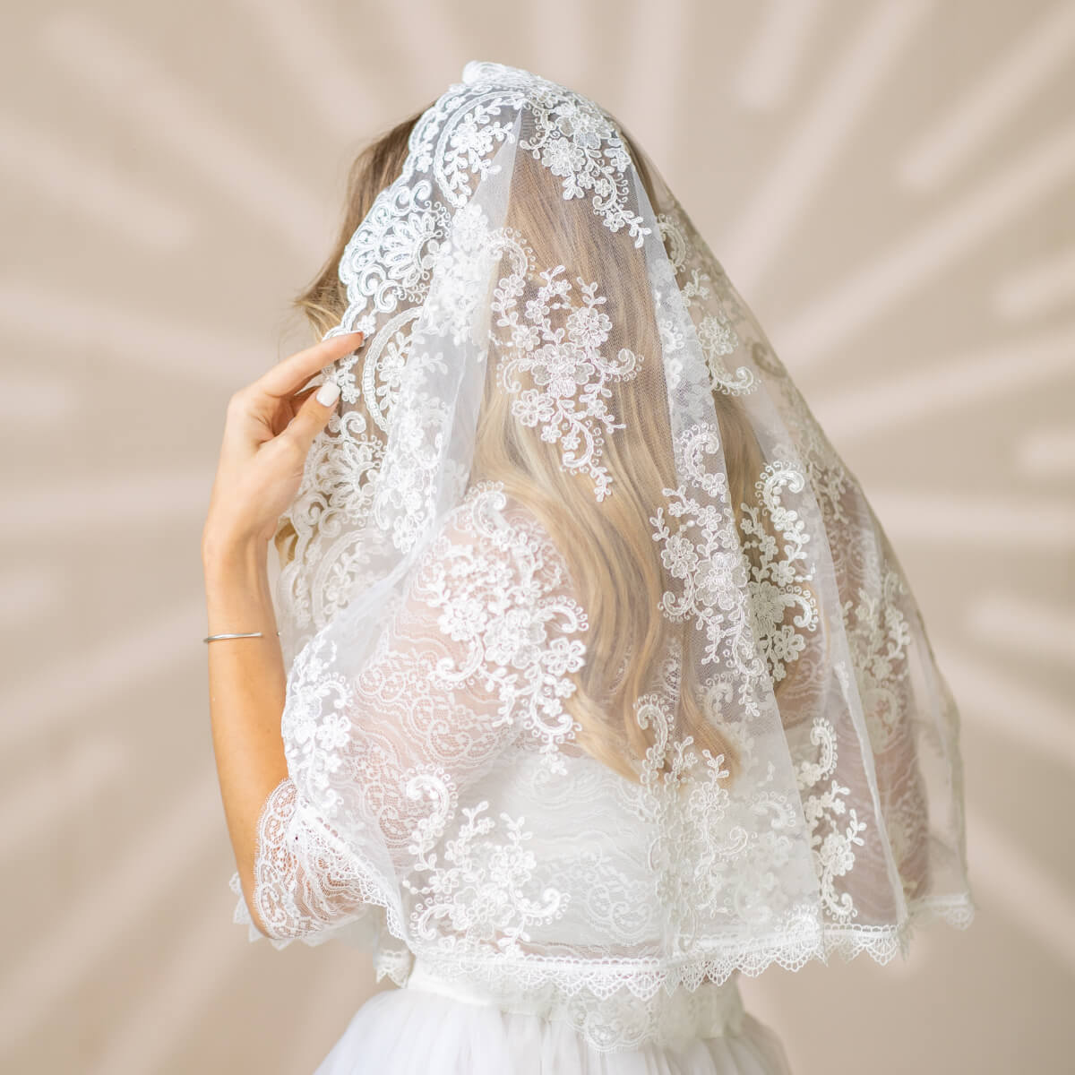 Bride wearing a Church Mantilla against a neutral background
