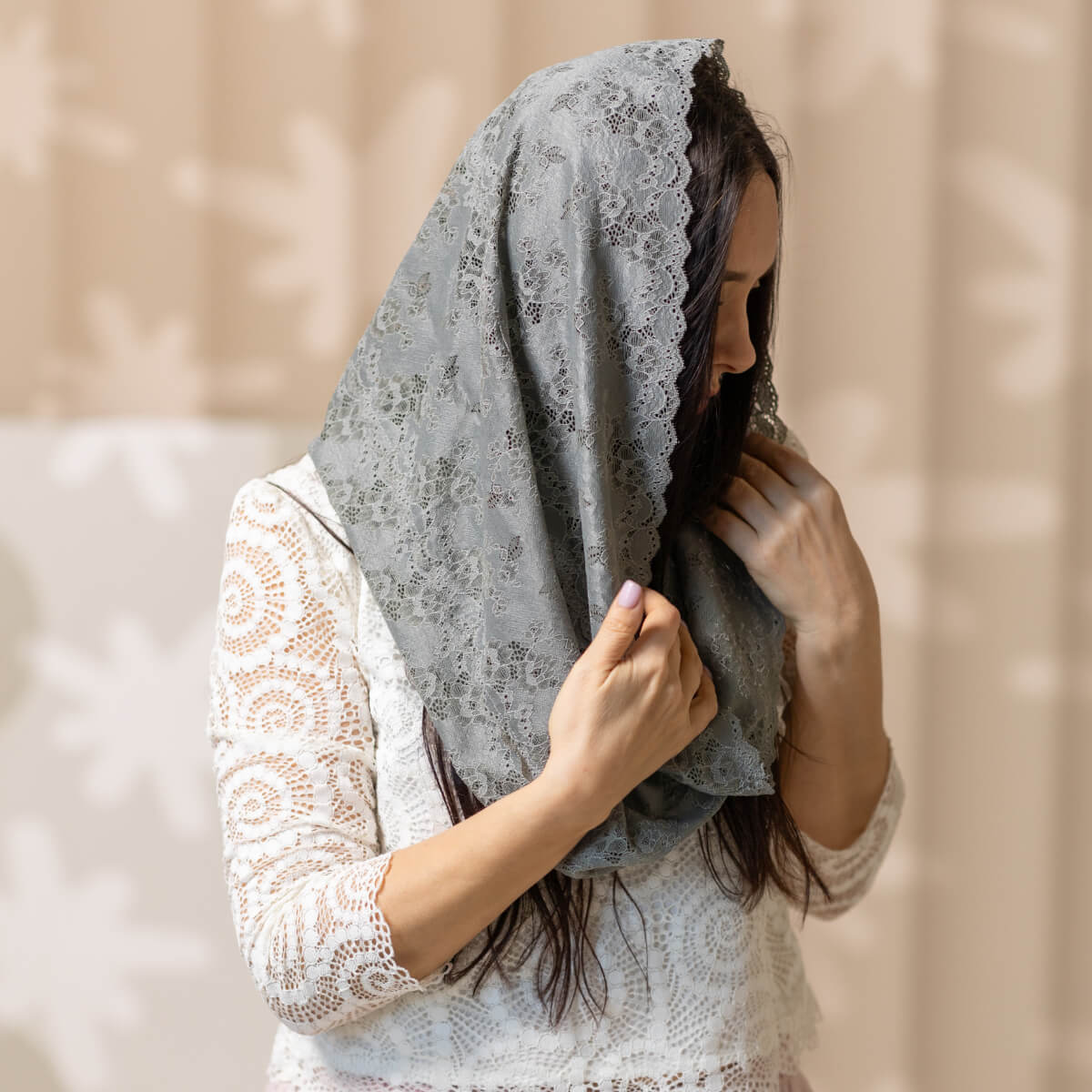Woman wearing a Catholic Infinity Veil against a beige background