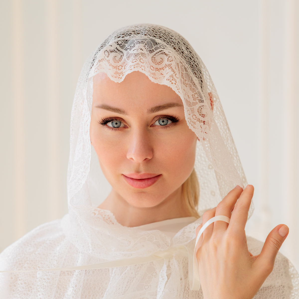 Woman wearing a Catholic Church Mantilla against a plain background