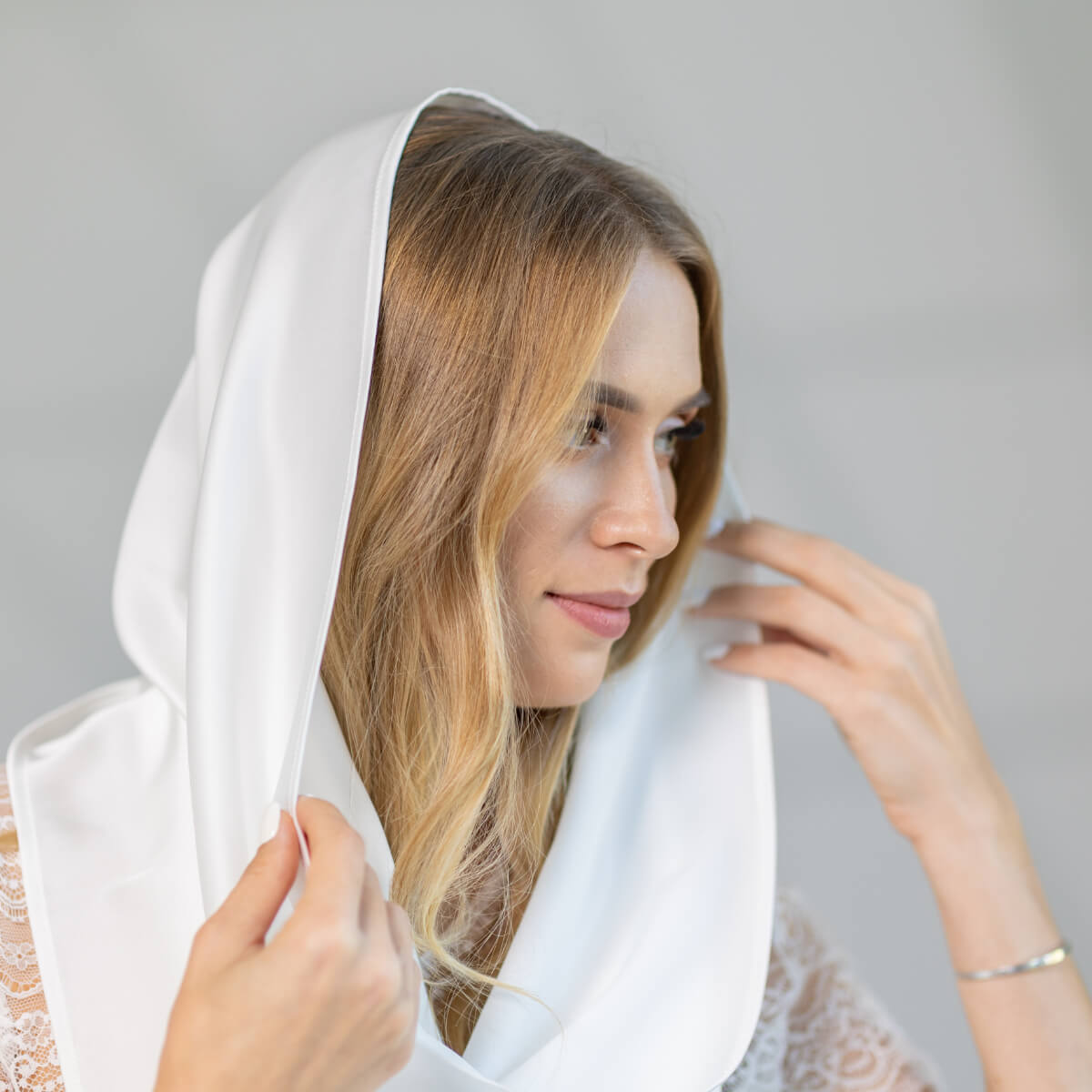 Woman wearing a Chapel Mantilla against a gray background
