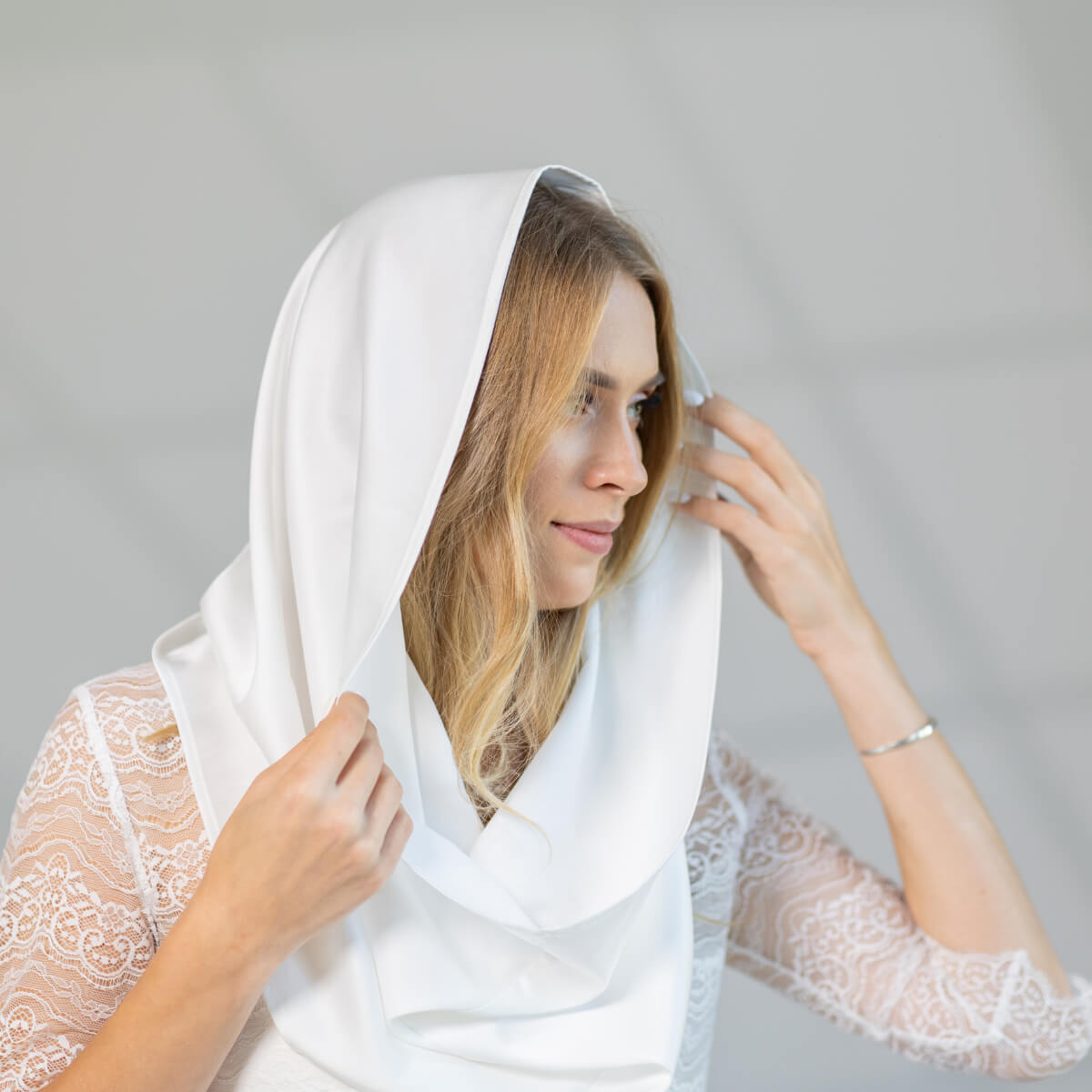 Woman wearing a Chapel Mantilla against a gray background