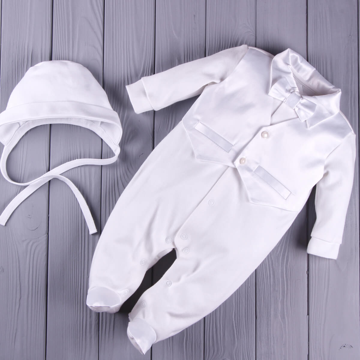 Newborn Coming Home Romper with hat on a wooden surface