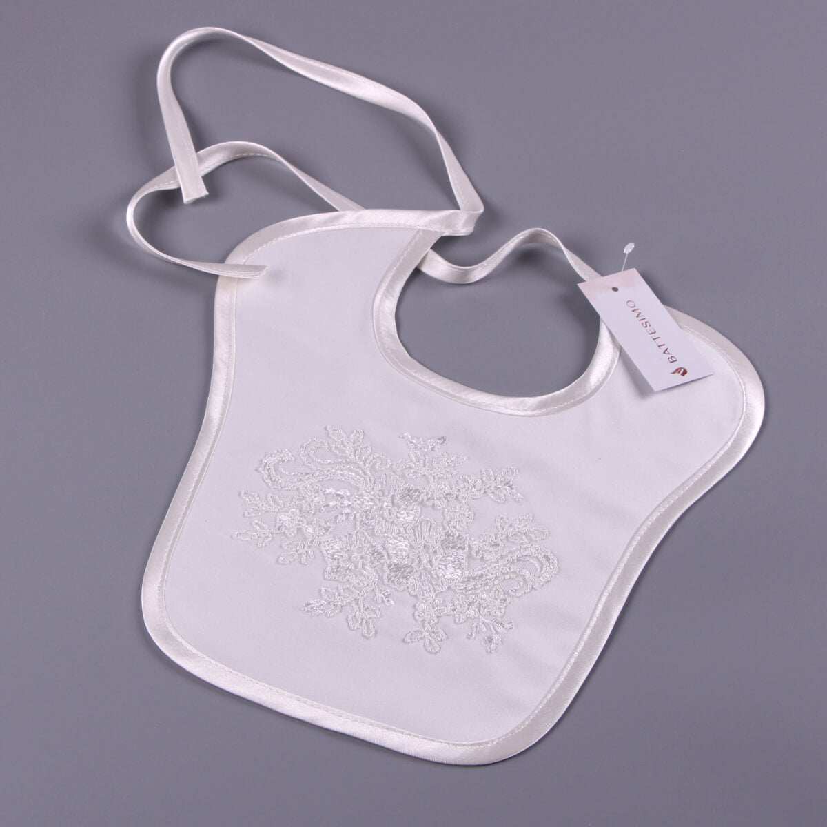 Newborn Bib with Lace details on a gray background