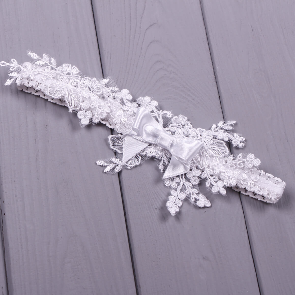 Baby headband with a bow on a wooden surface