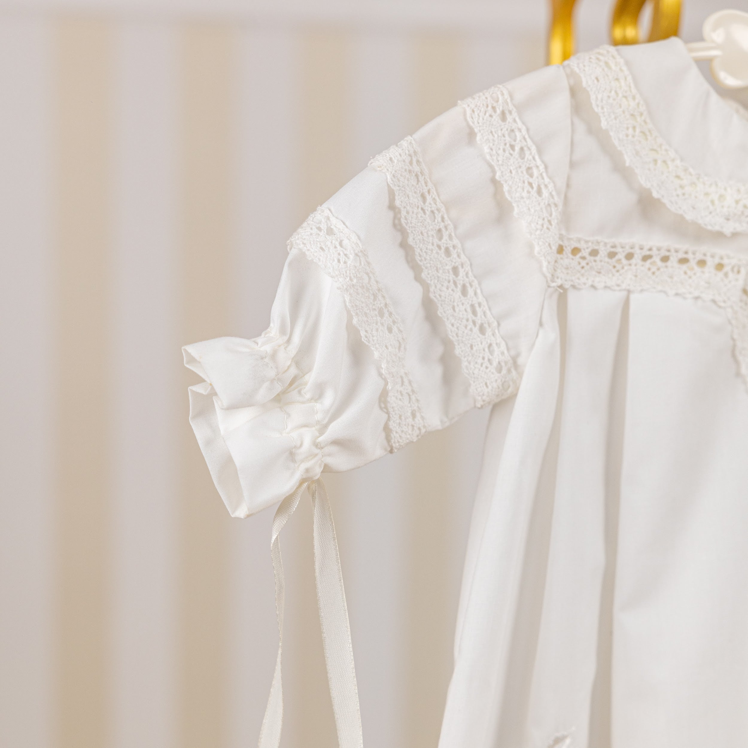 Girls Baptism Gown on a hanger with a neutral background