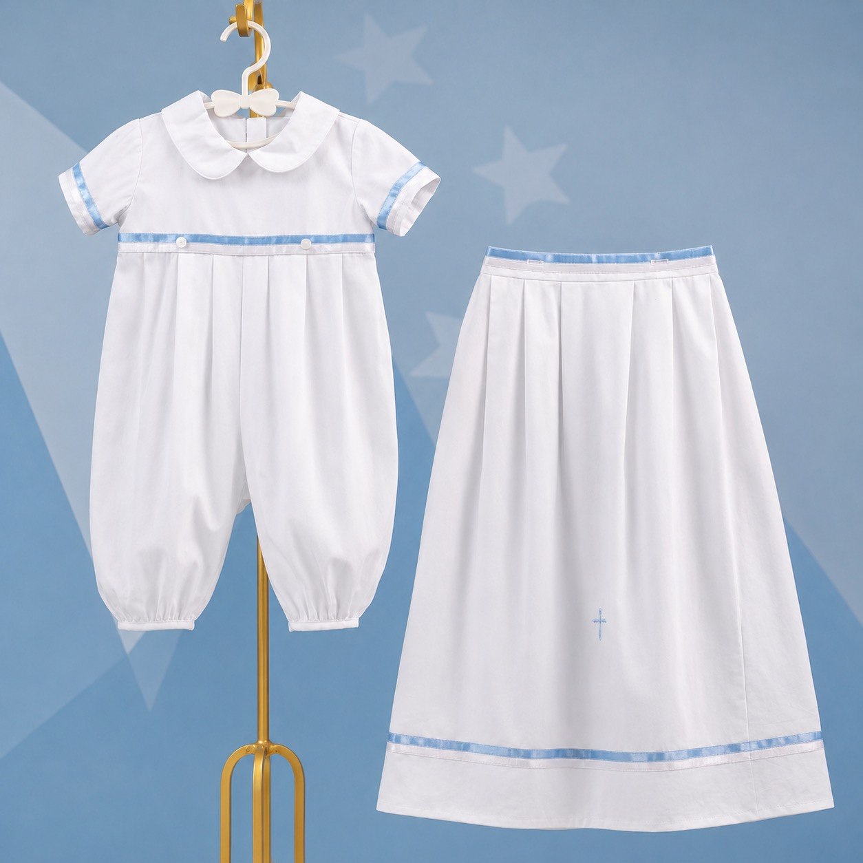 White boy convertible outfit fro christening with blue trim on a hanger against a blue background