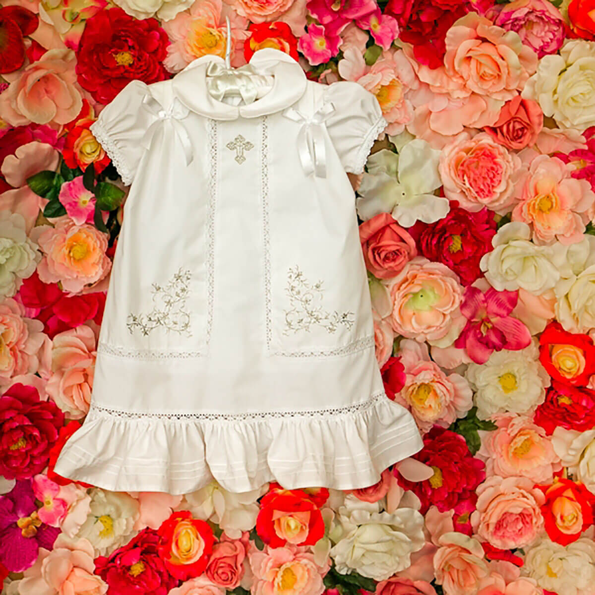 White Christening Dress with floral embroidery on a background of colorful flowers