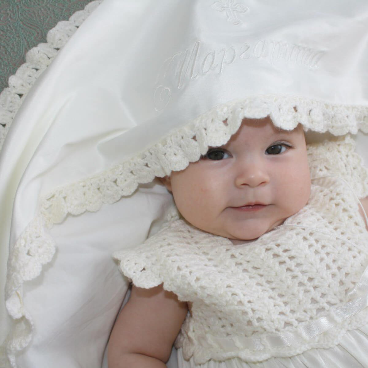Baby in a white lace outfit with a neutral background