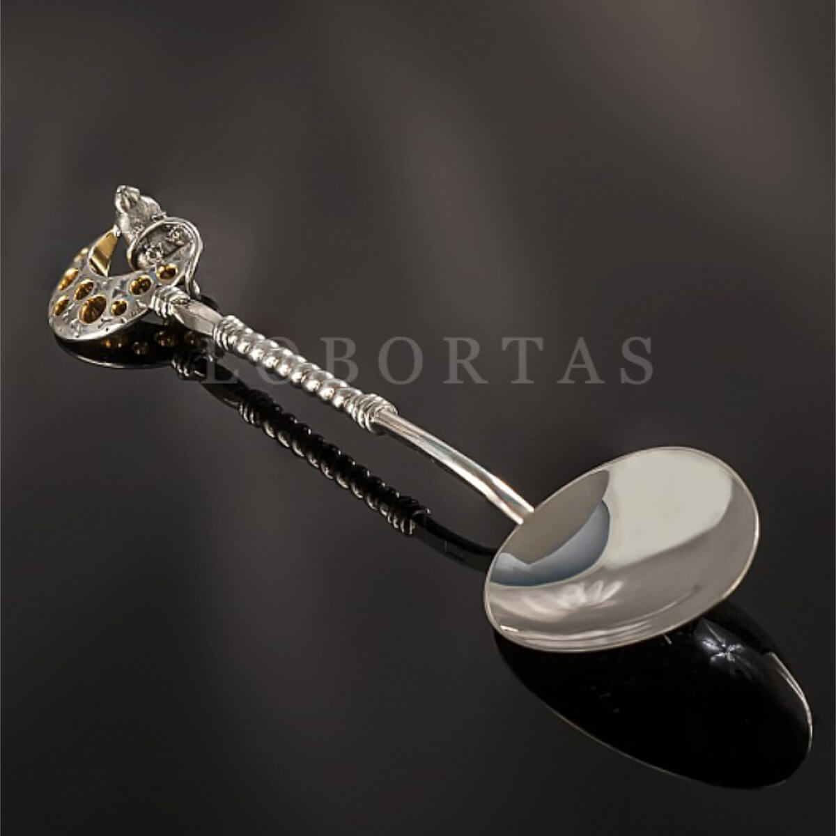 Silver spoon with decorative heart handle on a dark background