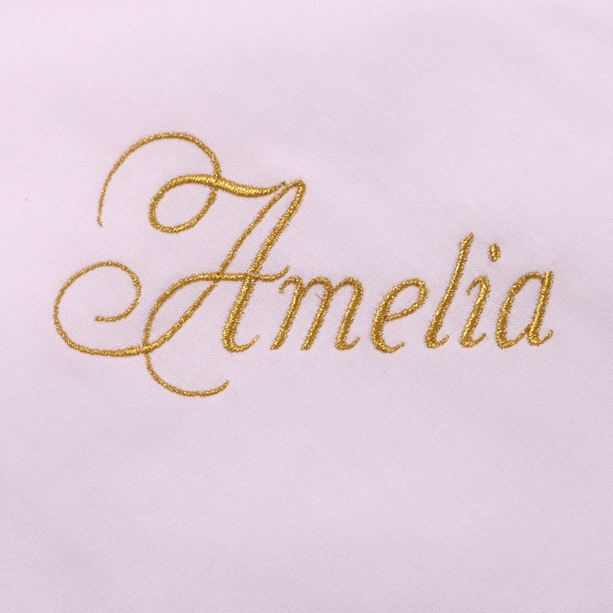 Gold embroidered name 'Amelia' on a light pink background