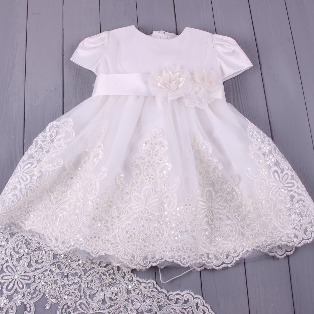 Lace Christening Dress on a wooden surface