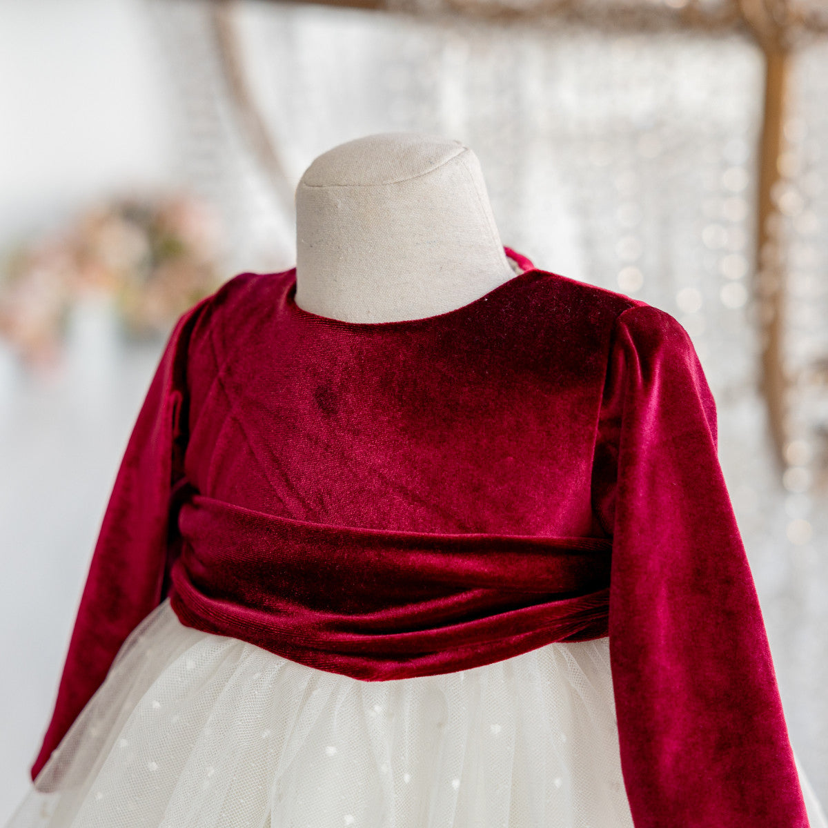 Red velvet top on a mannequin with a blurred natural background