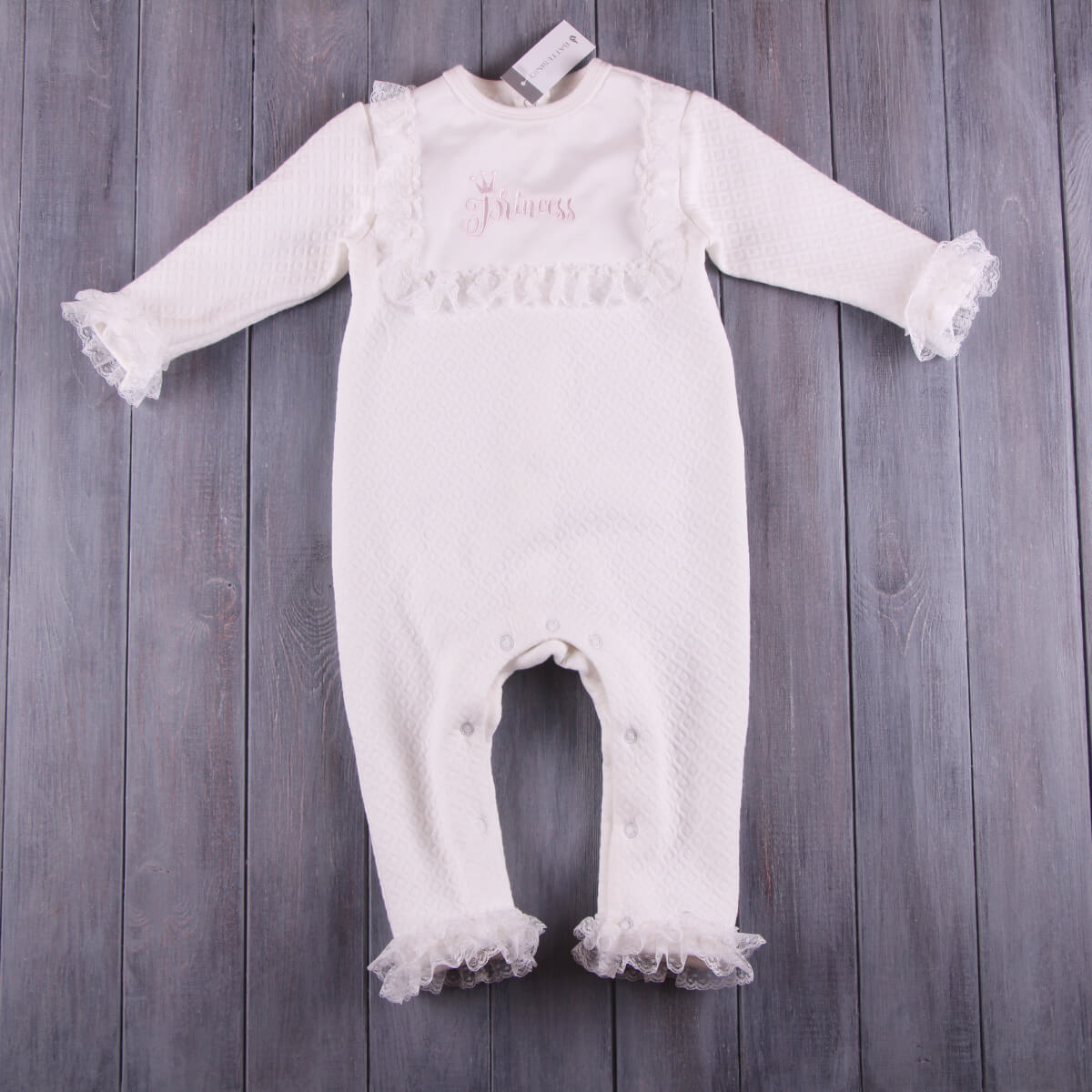 Baptism Romper Set with lace details on a wooden surface