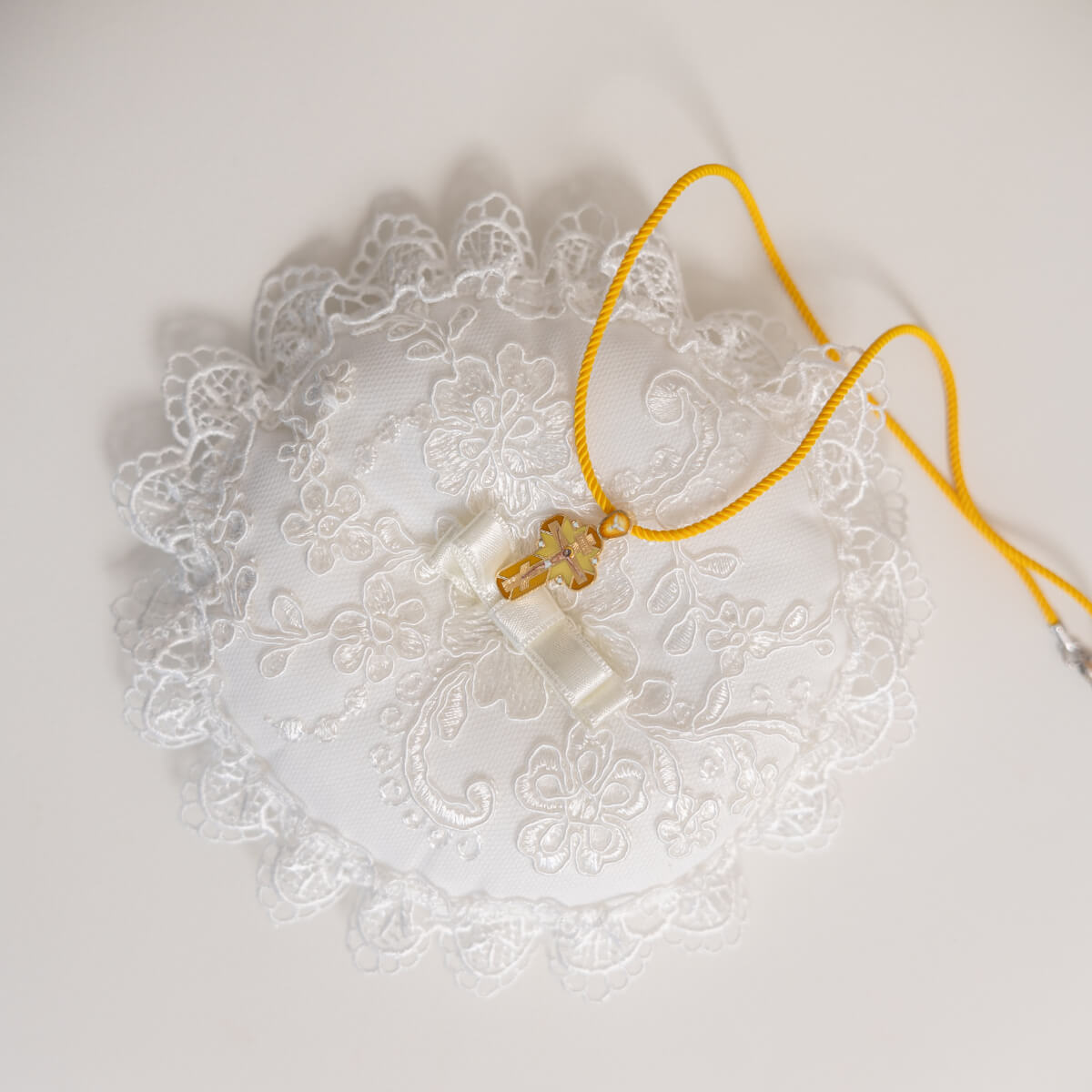 Necklace with a yellow cord on a Ceremony Pillow