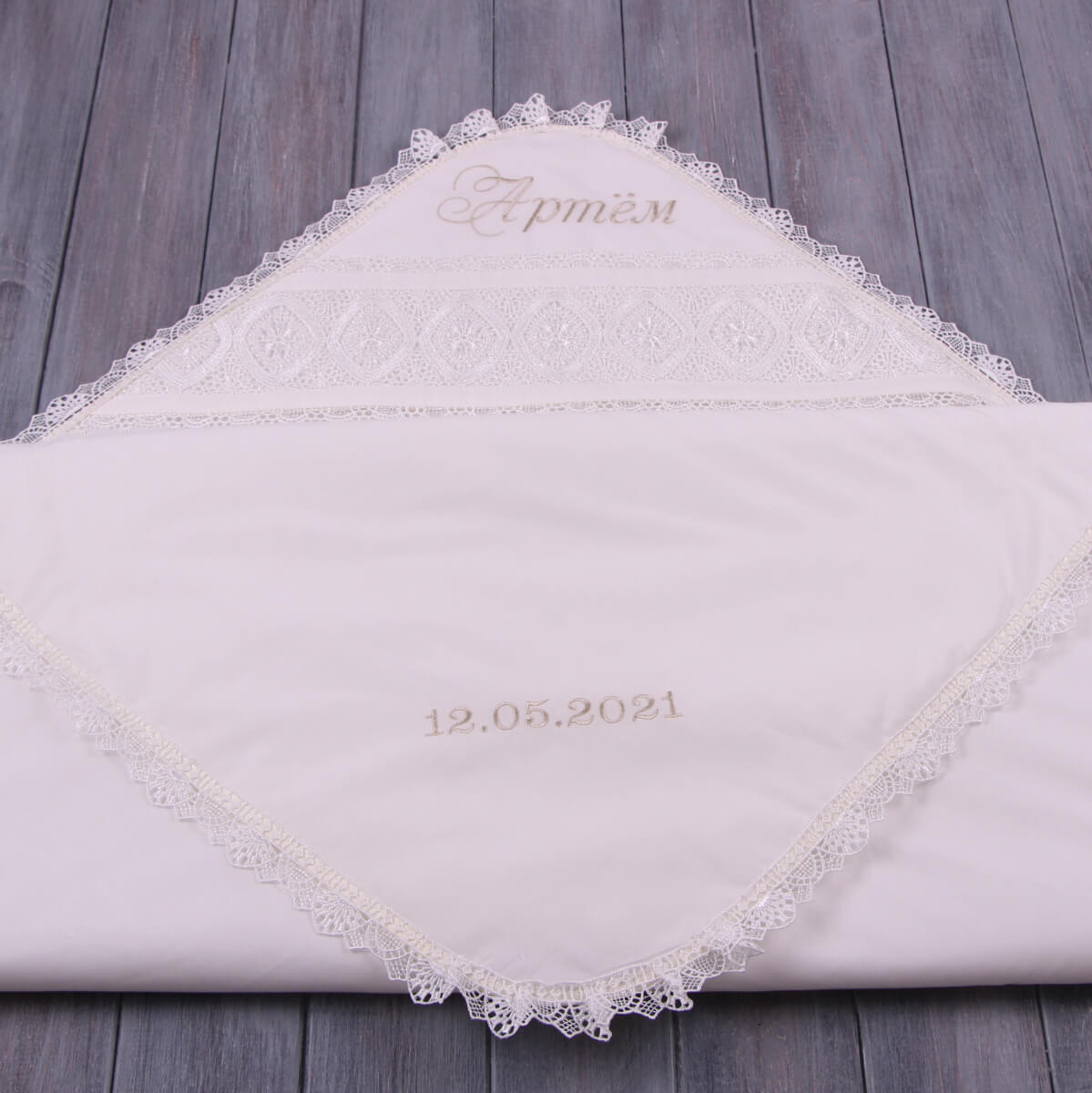 Personalized Baby Keepsake Blanket with lace trim and embroidered text on a wooden surface