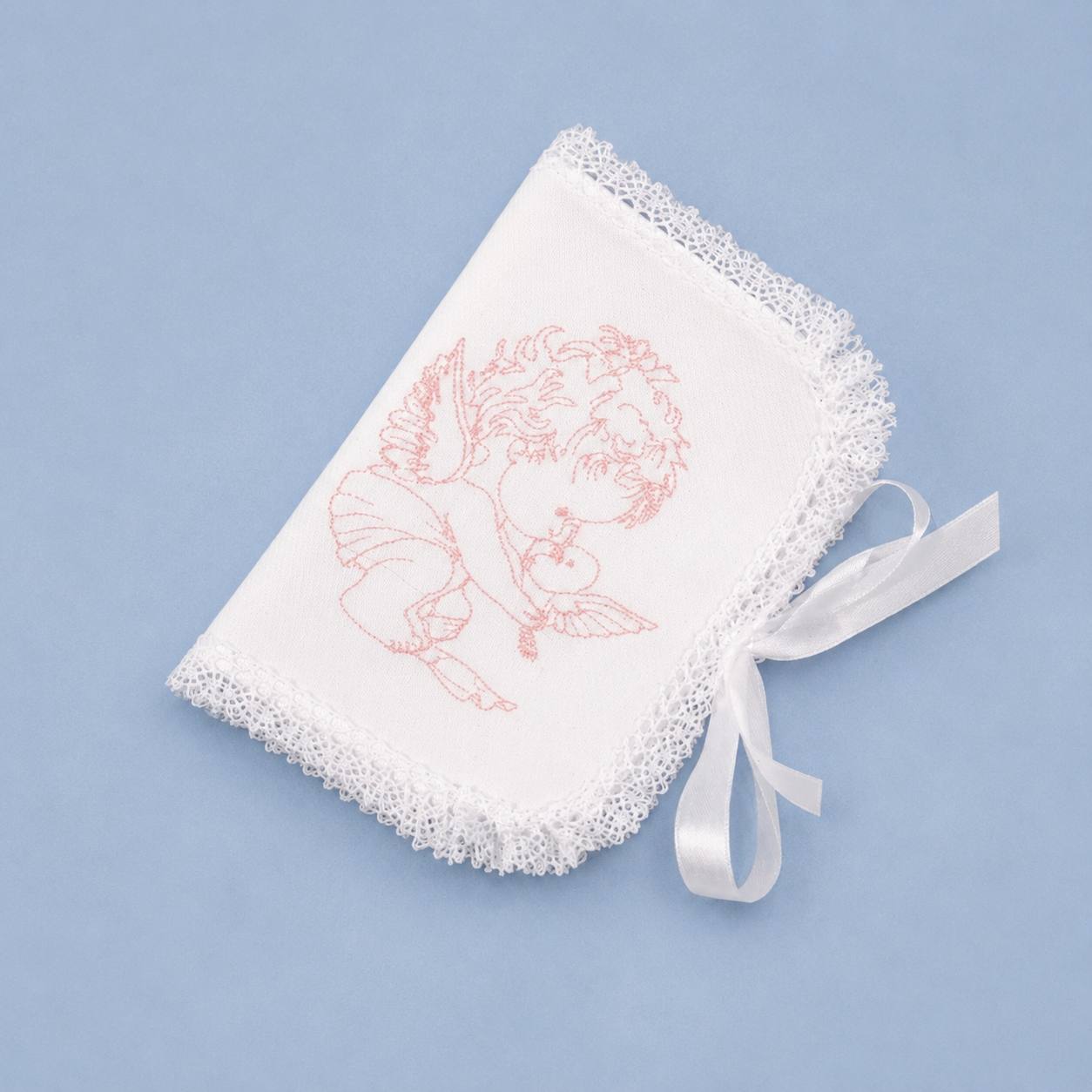 A white embroidered baby keepsake album or fabric pouch with a lace-trimmed edge, featuring a pink embroidered cherub design and a white satin ribbon bow, set against a solid light blue background.