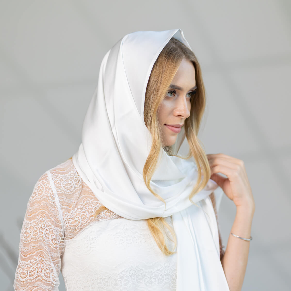 Woman wearing a Church Mantilla against a gray background