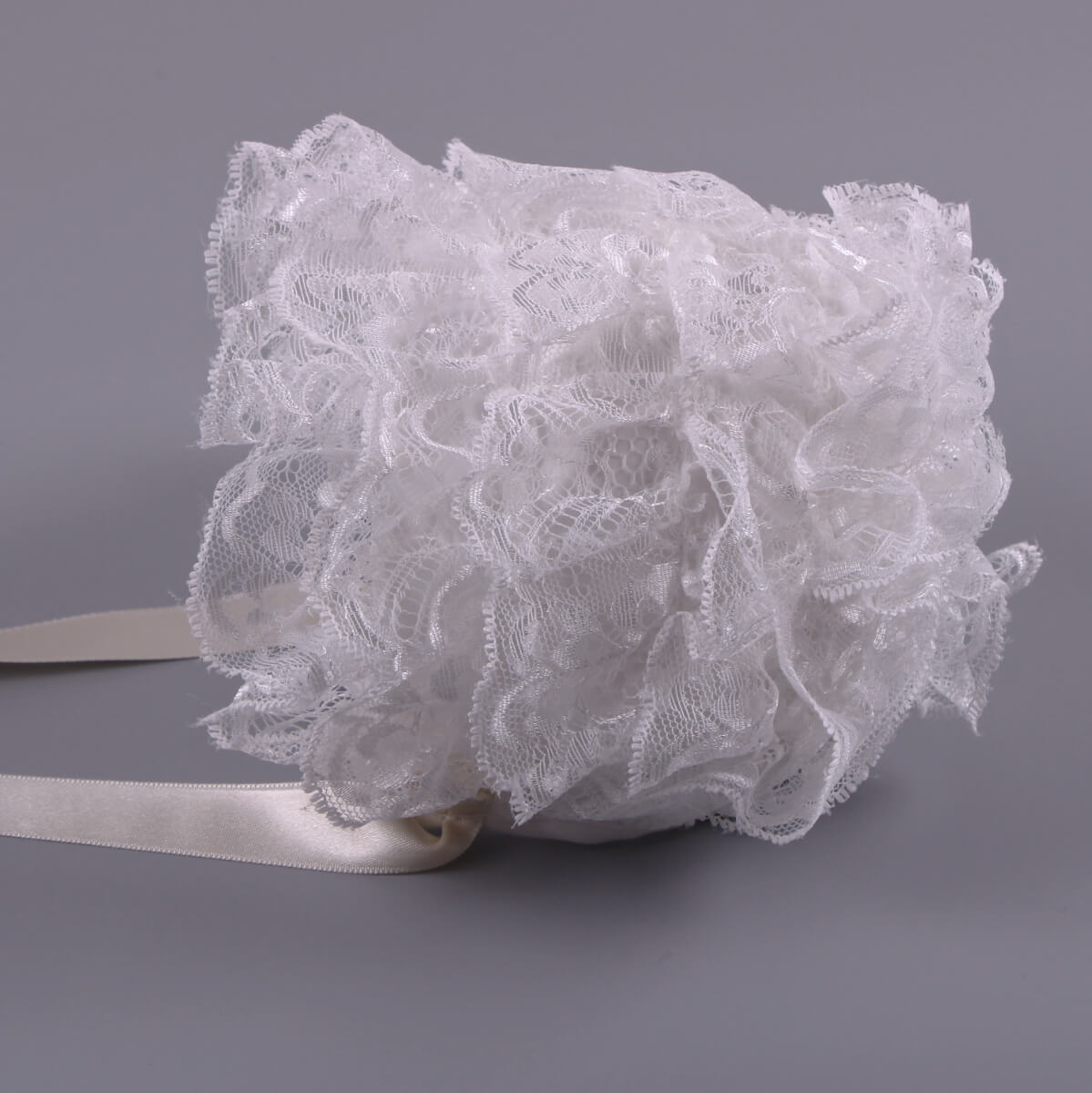 White lace baptism bonnet on a gray background