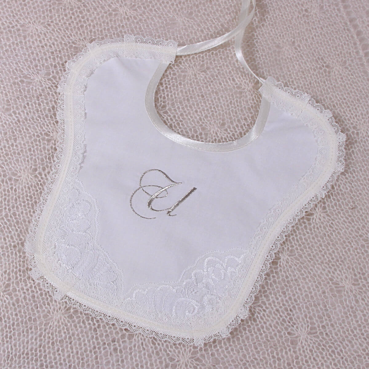 Newborn Lace Bib on a textured beige background