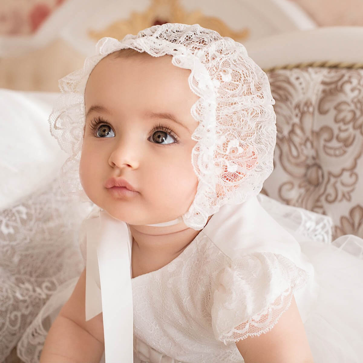 Baby wearing a Lace Baptism Bonnet with a neutral background