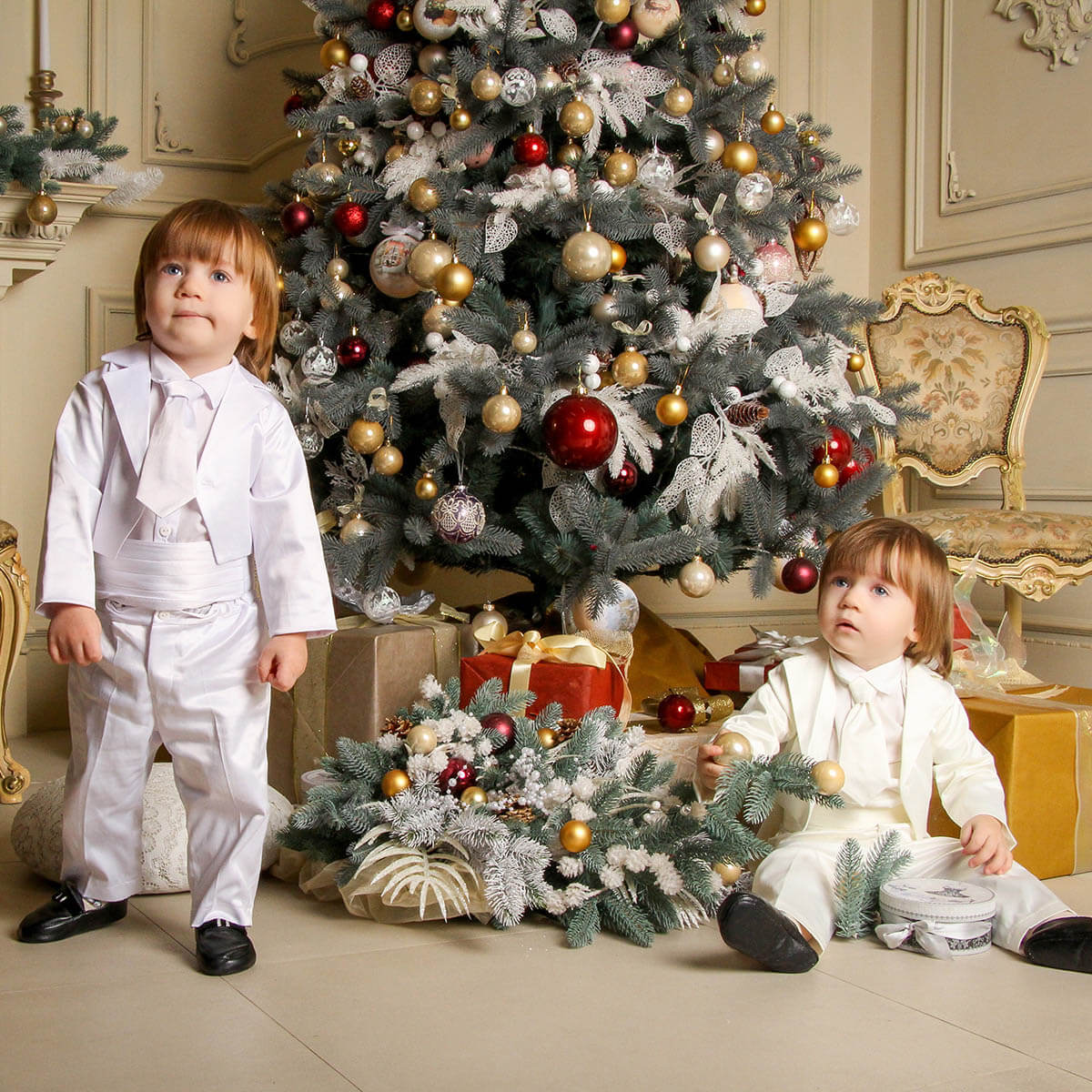 Two children in Baby Boy Baptism Suit standing in front of a decorated Christmas tree.