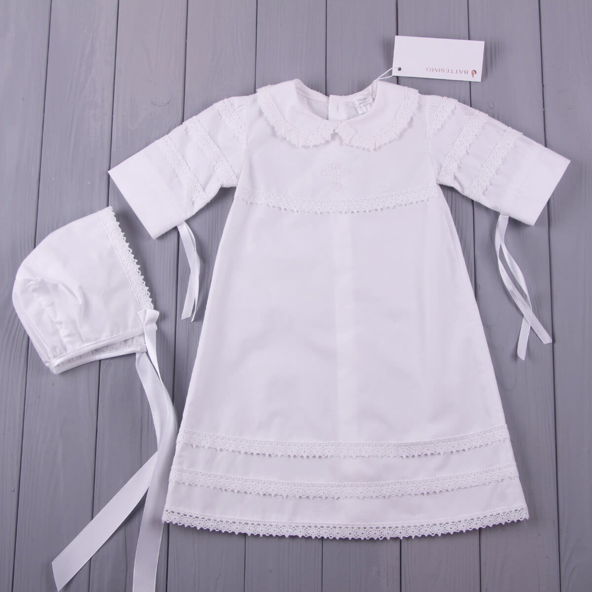 Baptism Gown with bonnet on a gray wooden surface