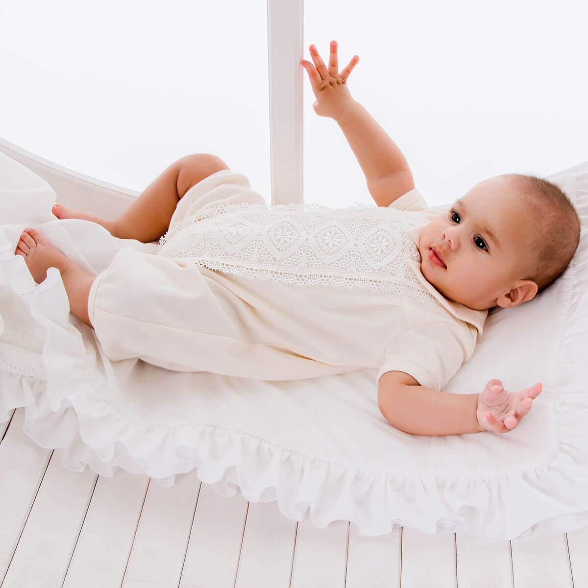Baby in a Handmade Baptism Outfit lying on a white surface