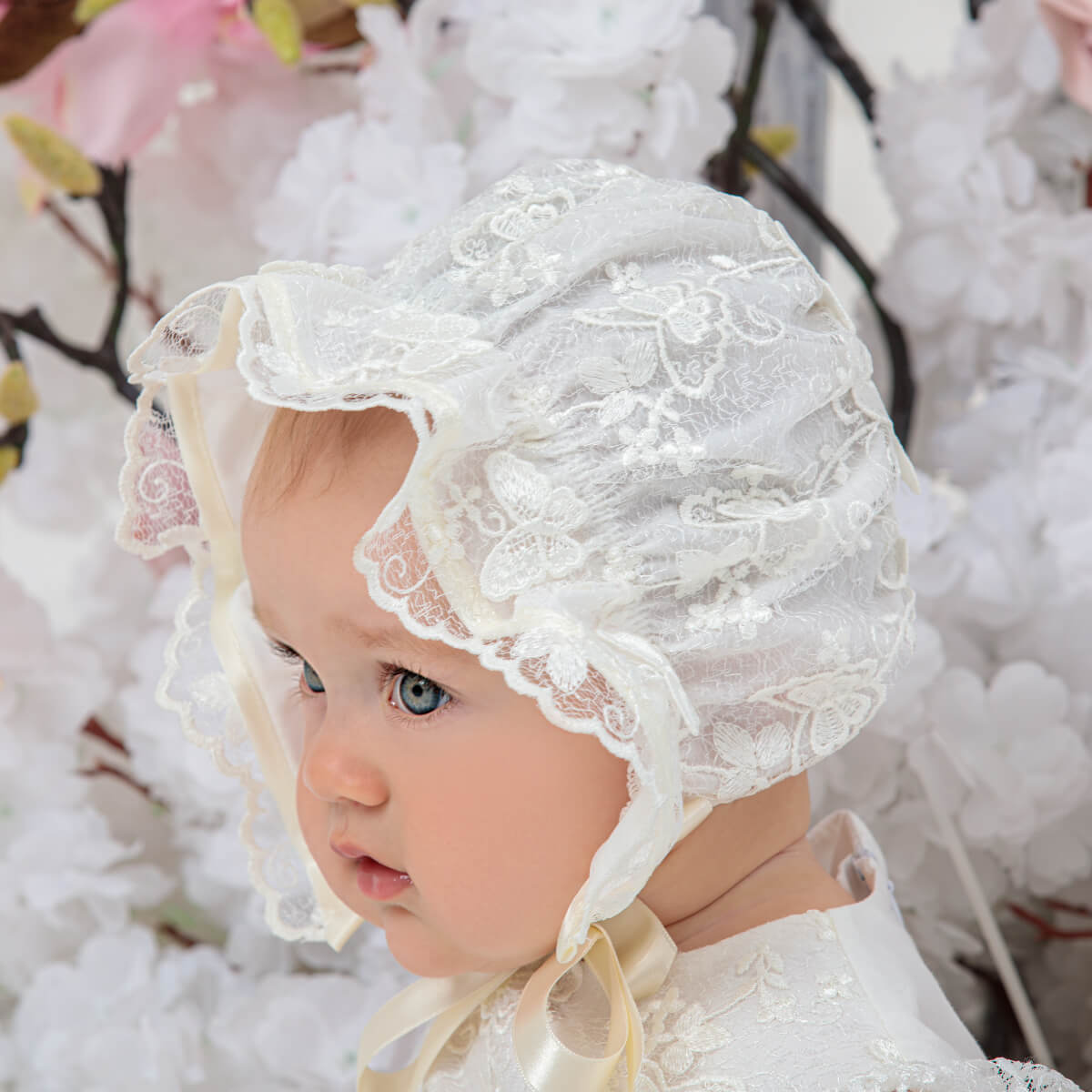 Baby wearing a vintage baby bonnet with a floral background
