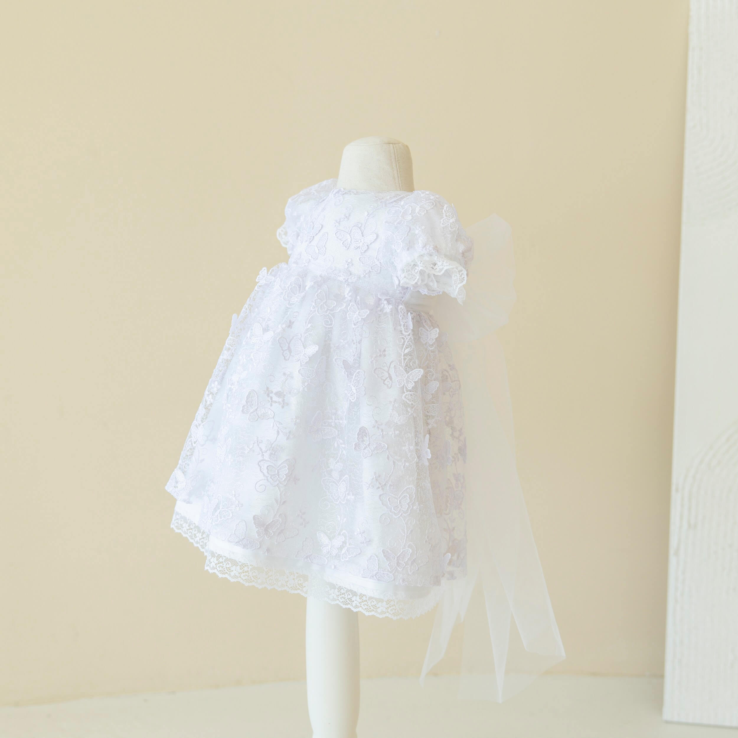 Baptism Dress with Lace on a mannequin against a beige background