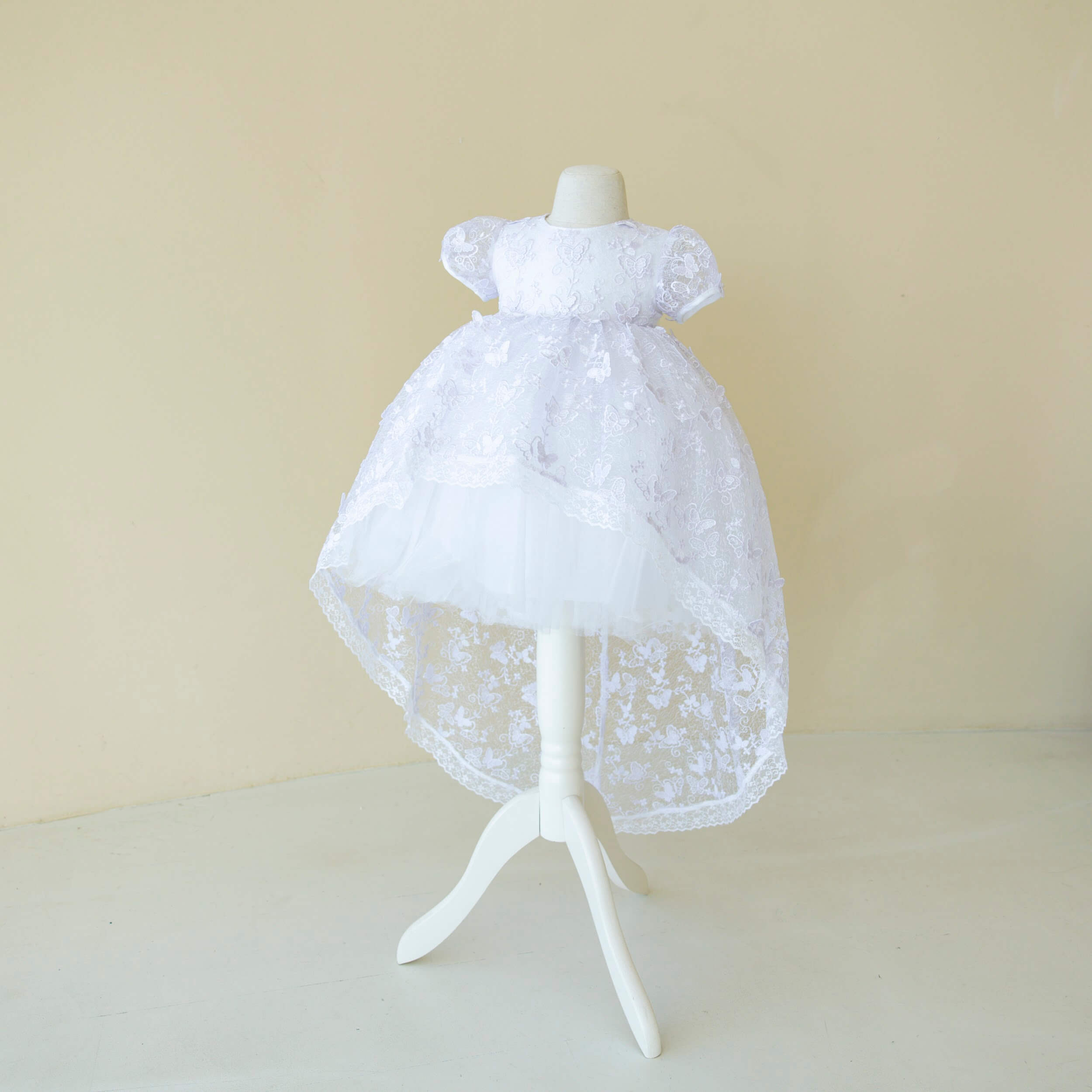 Baptism Dress with Lace on a mannequin against a beige background