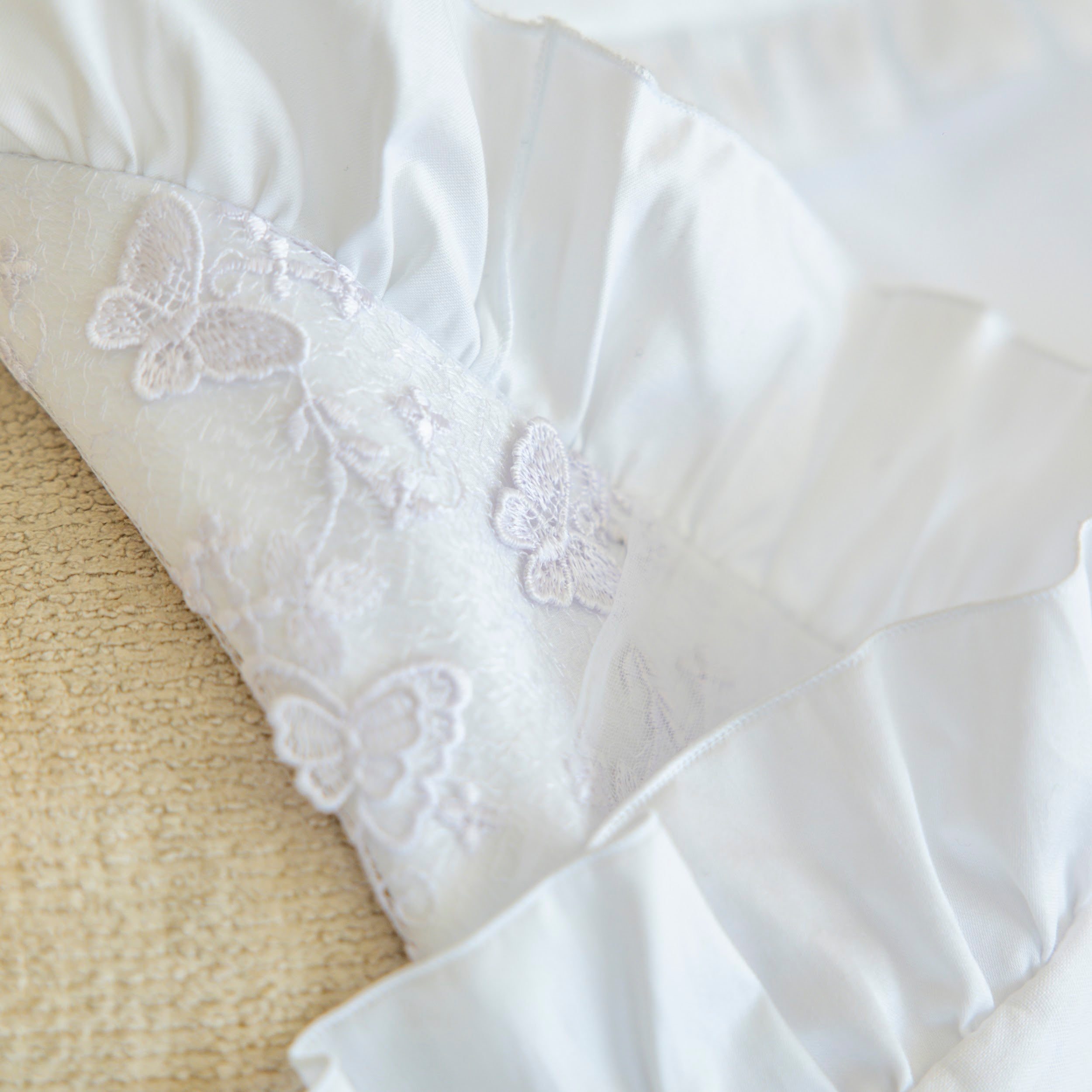 White fabric with butterfly embroidery on a textured surface