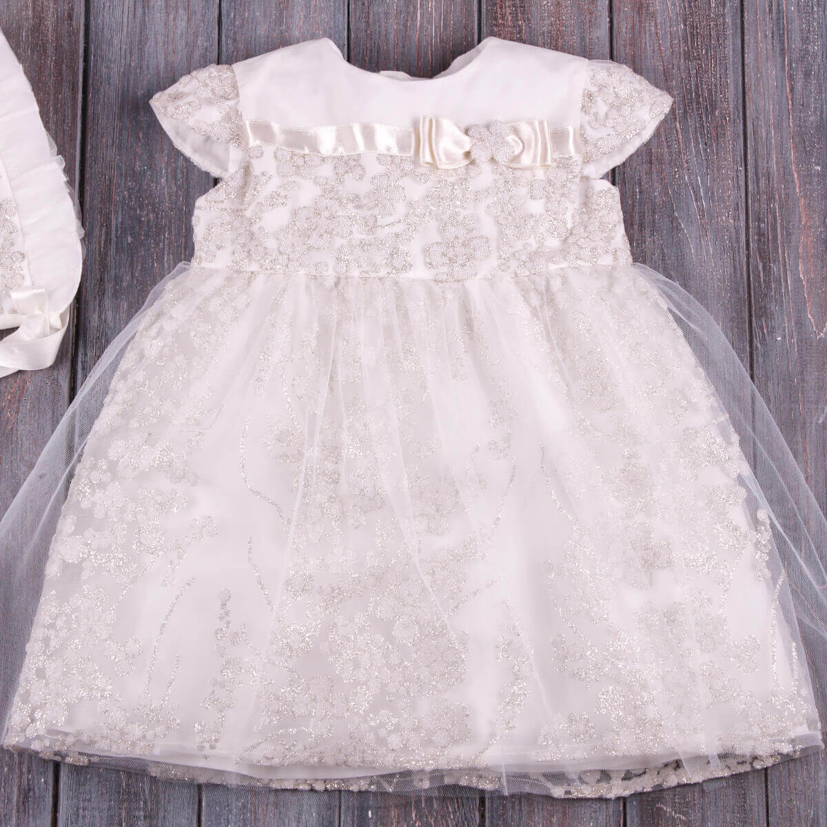 Baby Baptism Dress on a wooden surface