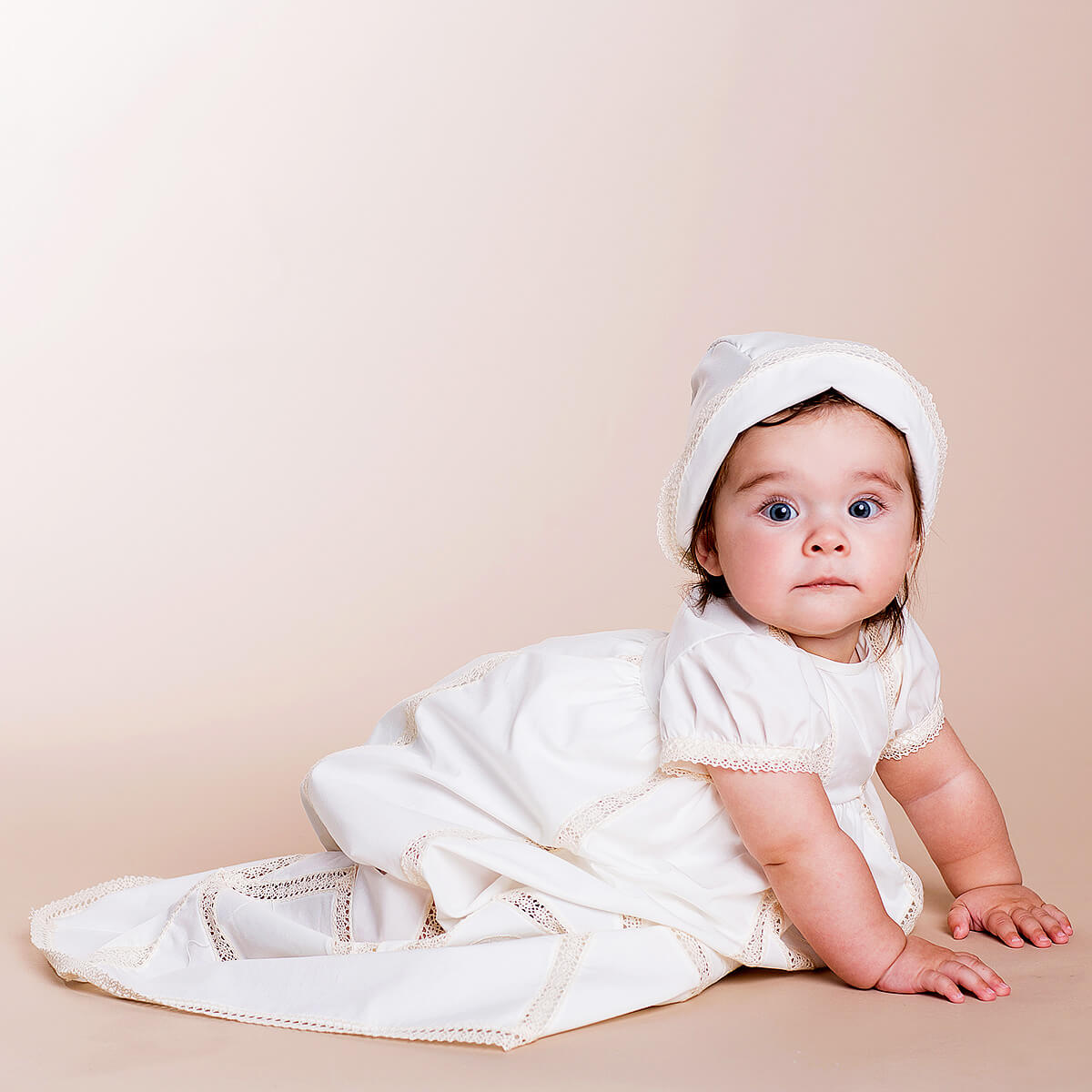 Baby in a Christening Gown for Girls with a hood on a beige background