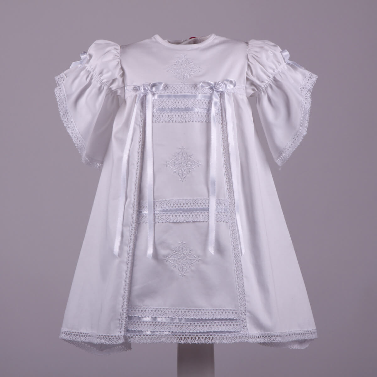 Heirloom Christening Dress with lace details on a gray background