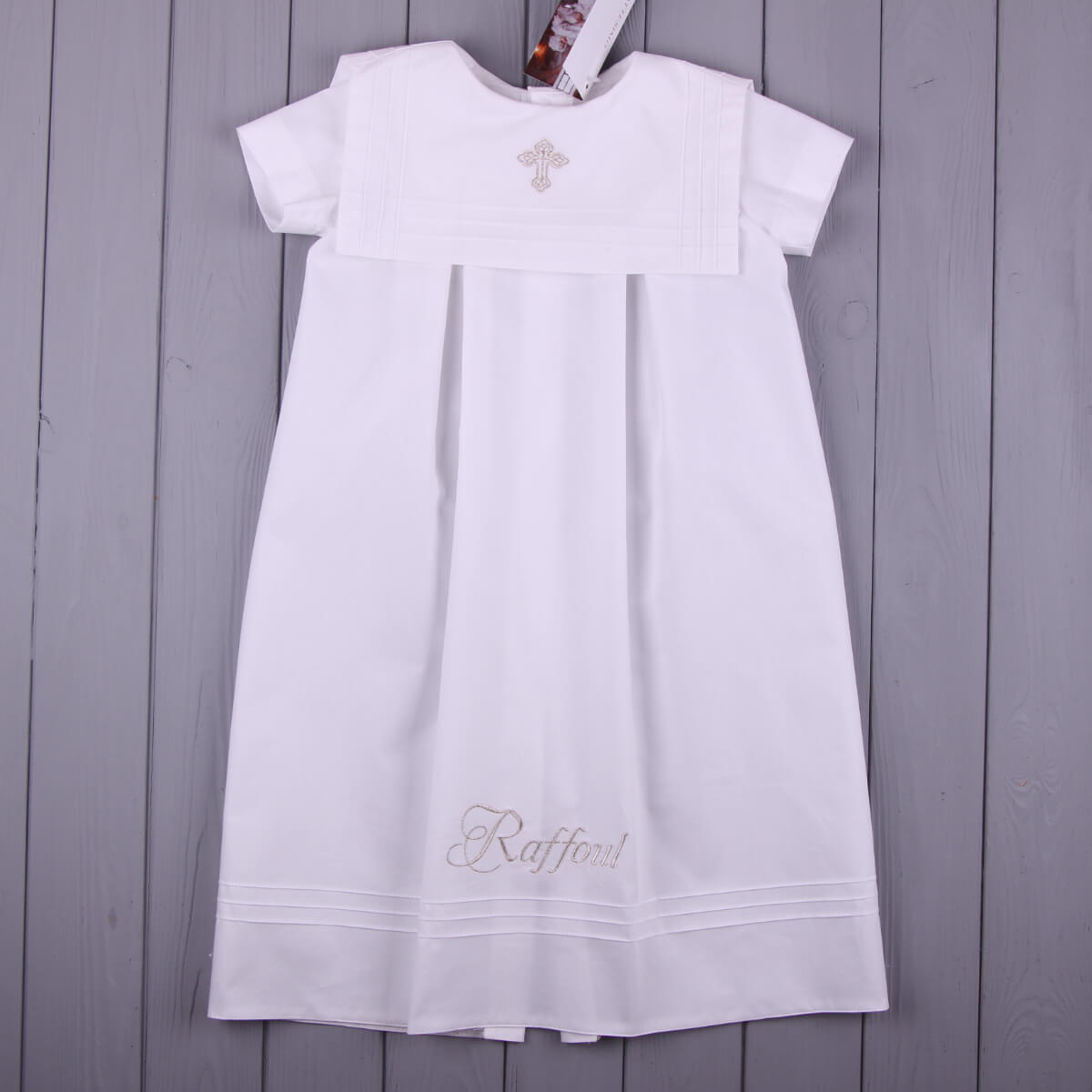 Christening outfit with embroidery on a wooden surface