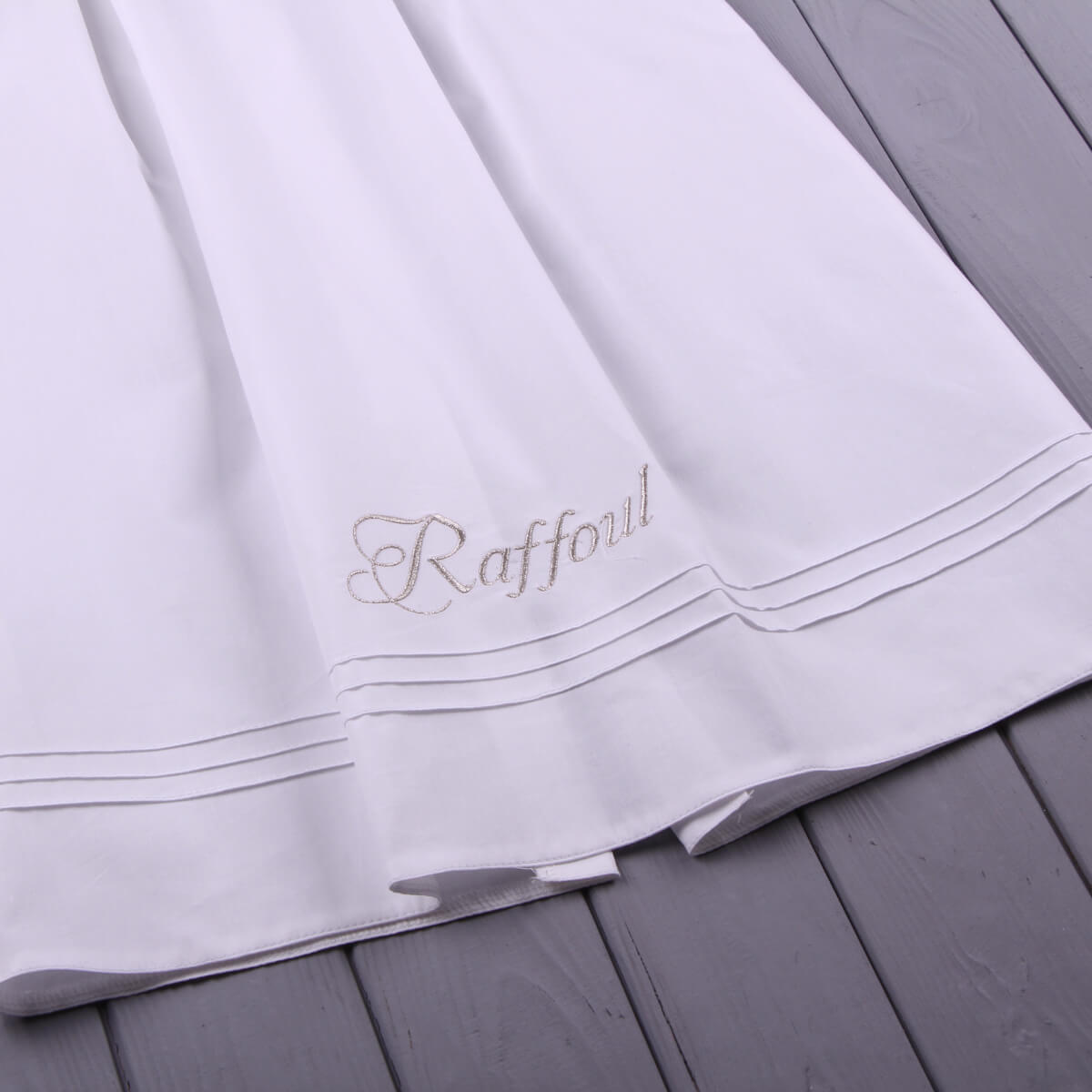 christening outfit with embroidery on a wooden surface