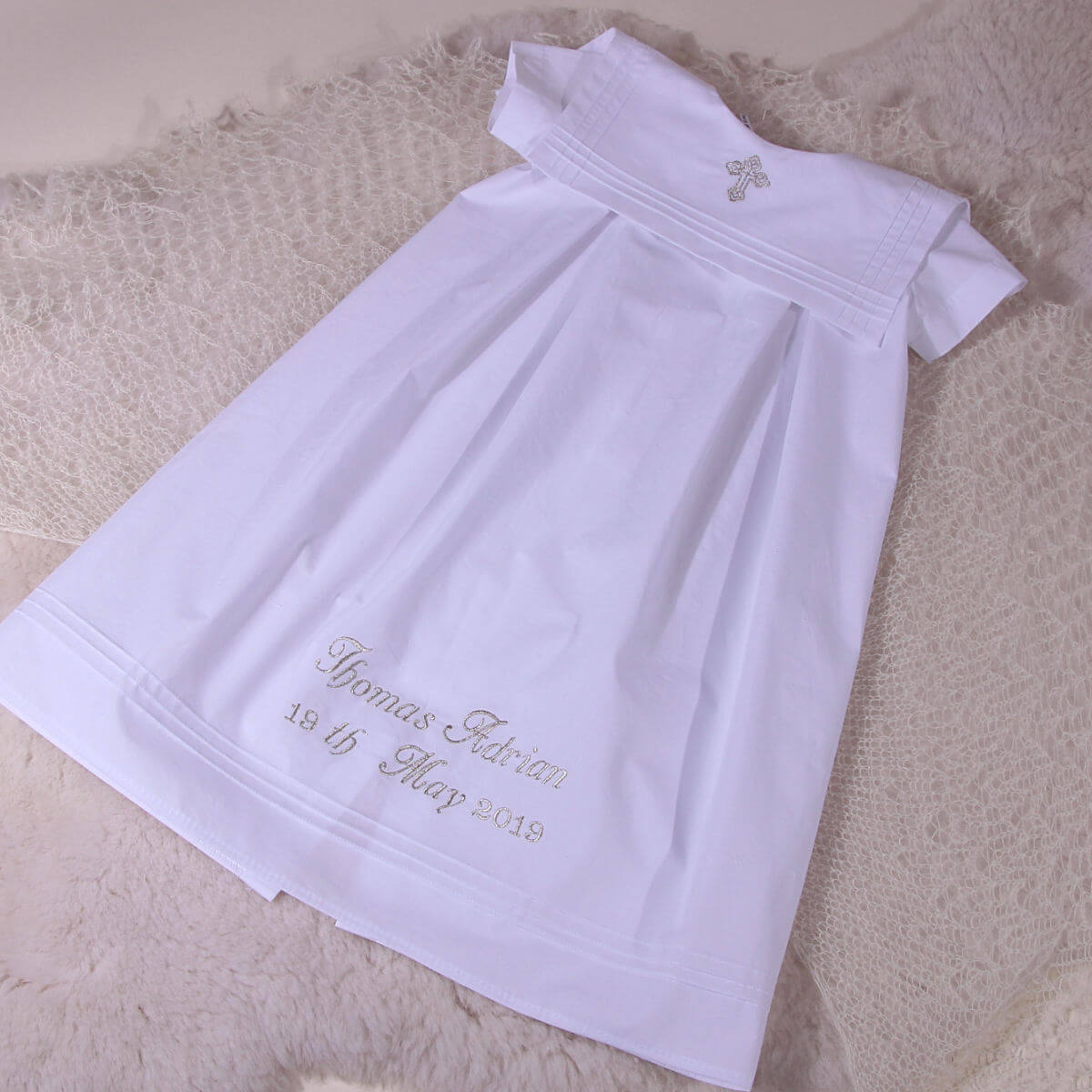 christening outfit s with embroidery on a textured surface