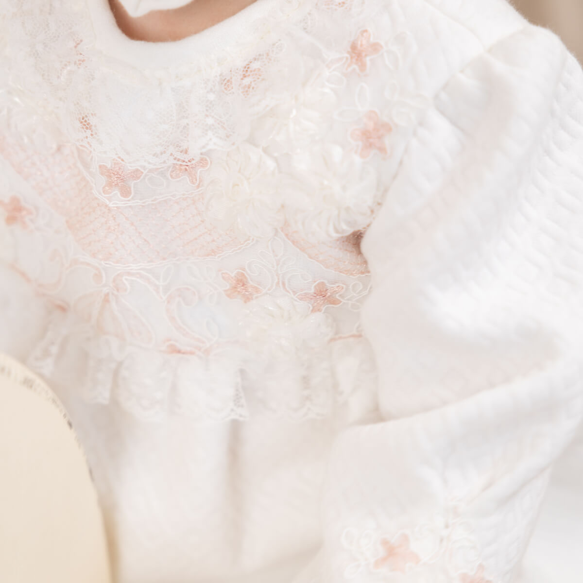 Close-up of a Newborn Coming Home Dress with floral patterns.