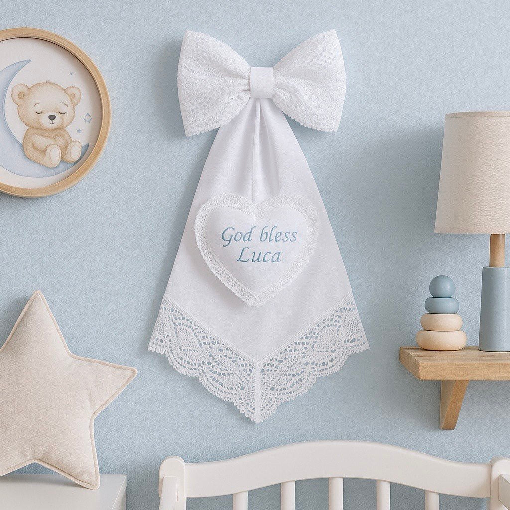 Personalized Baby Keepsake with embroidered text on a light blue wall in a nursery setting.