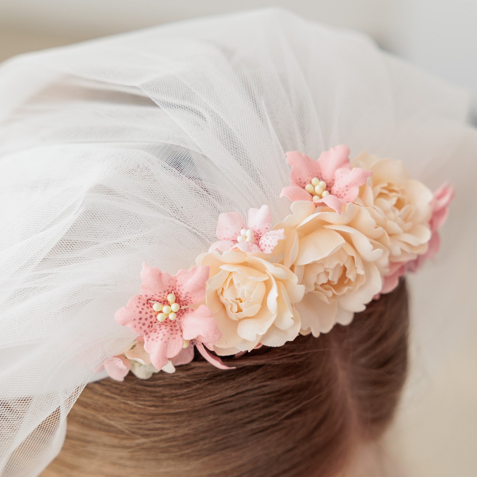 Floral headband with pink and beige flowers on a blurred background