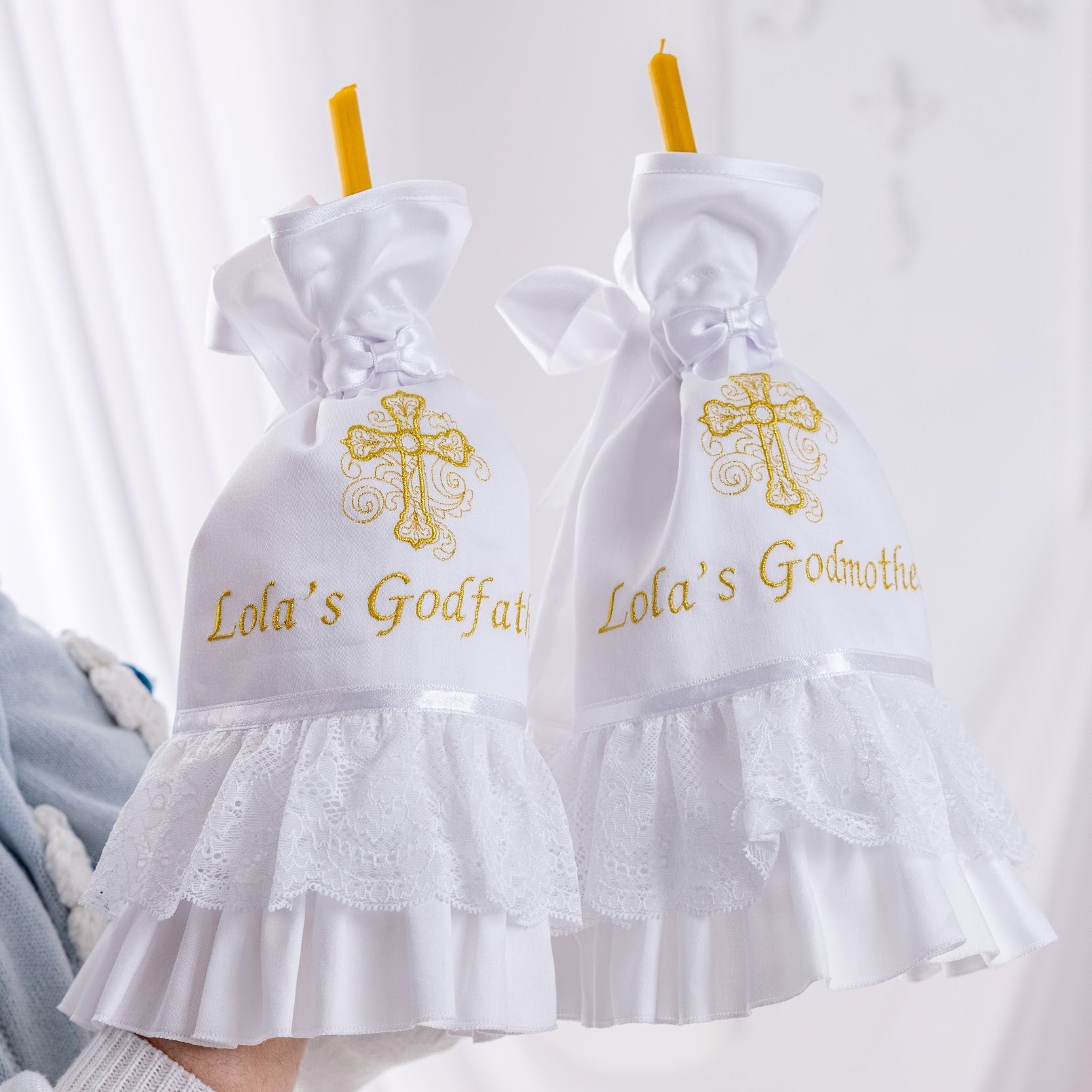 White godmother and godfather candle wraps with ruffles and crosses on a white background