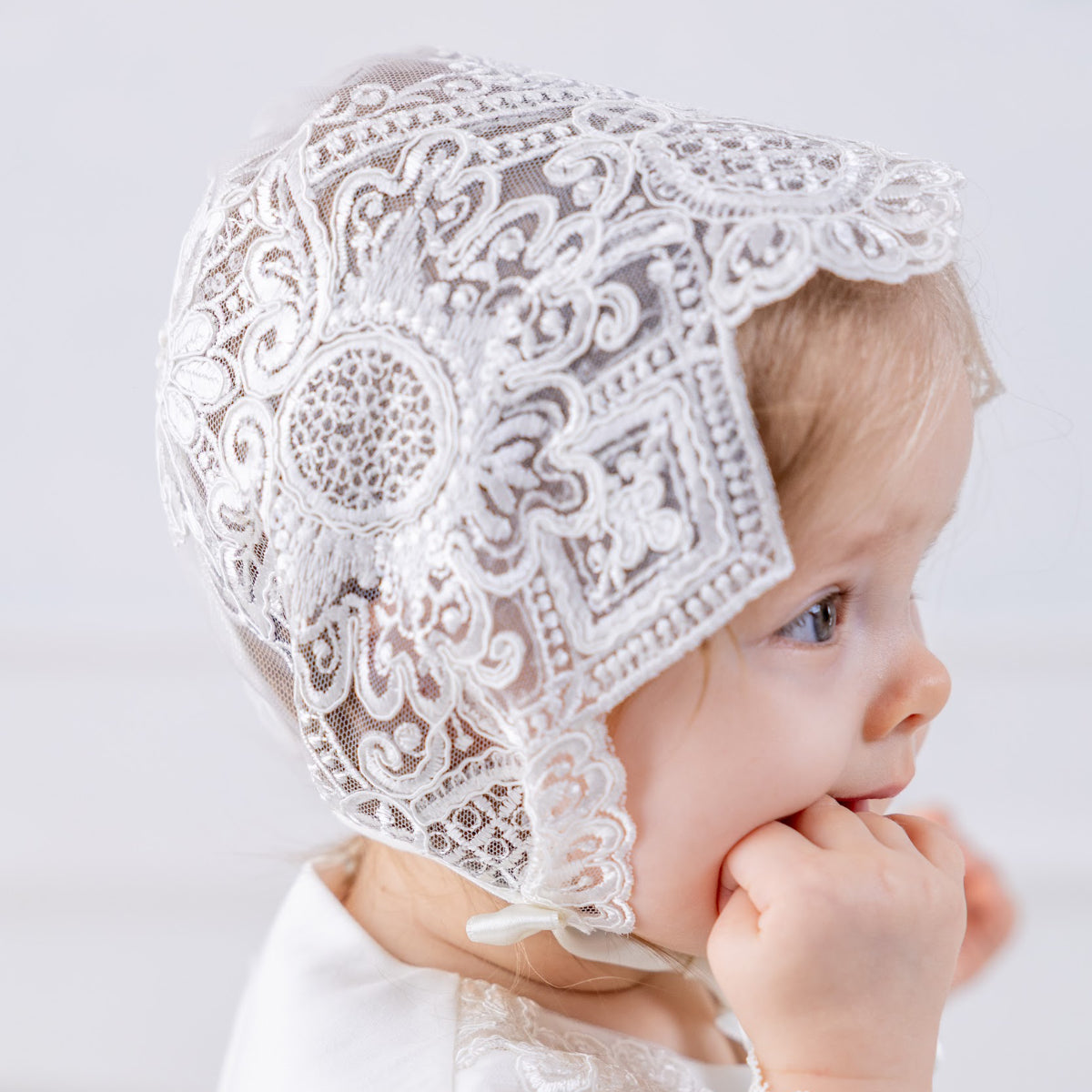 Baby in a  lace baptism bonnet