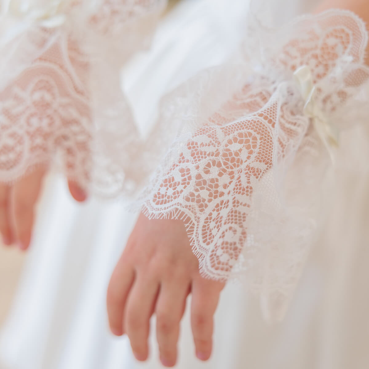 Close-up of a hand wearing a lace glove with a blurred background