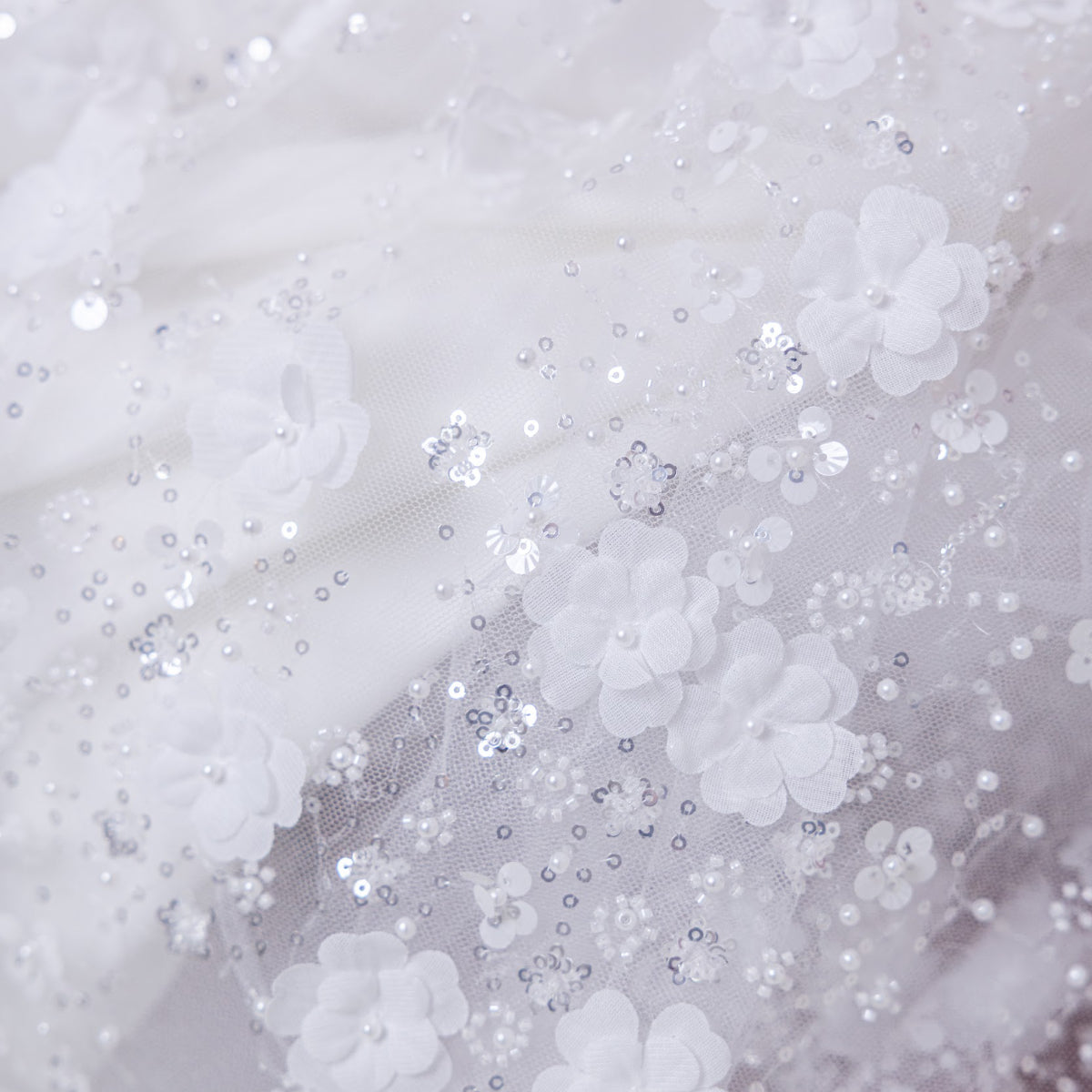 Close-up of white fabric with sequins and beads