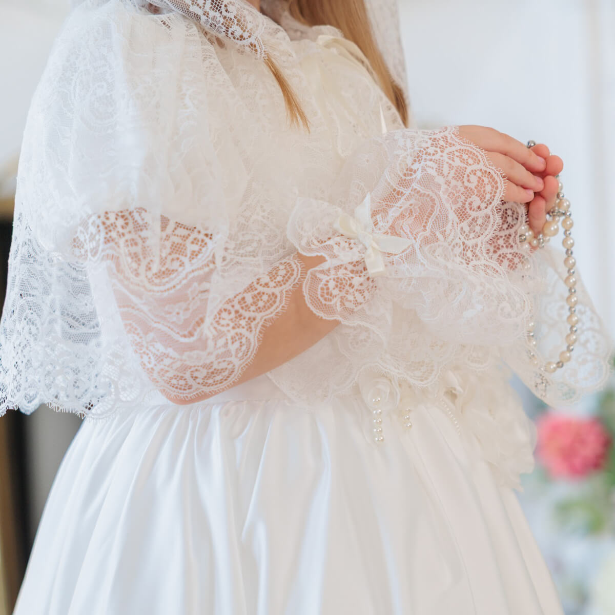 Close-up of a white lace dress with a blurred background